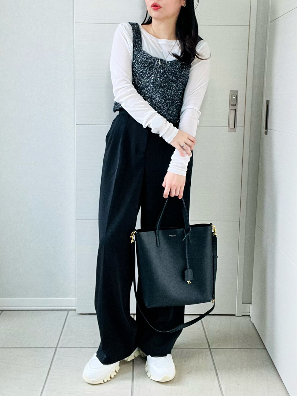 ブラック系のベスト、ホワイト系のTシャツ/カットソー、ブラック系のスラックスを着用したレディースの秋コーディネートの4枚目の写真