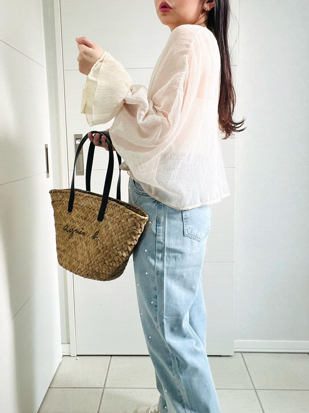 ベージュ系のカーディガン/ボレロ、ホワイト系のキャミソール、ブルー系のデニムパンツを着用したレディースの夏コーディネートの3枚目の写真