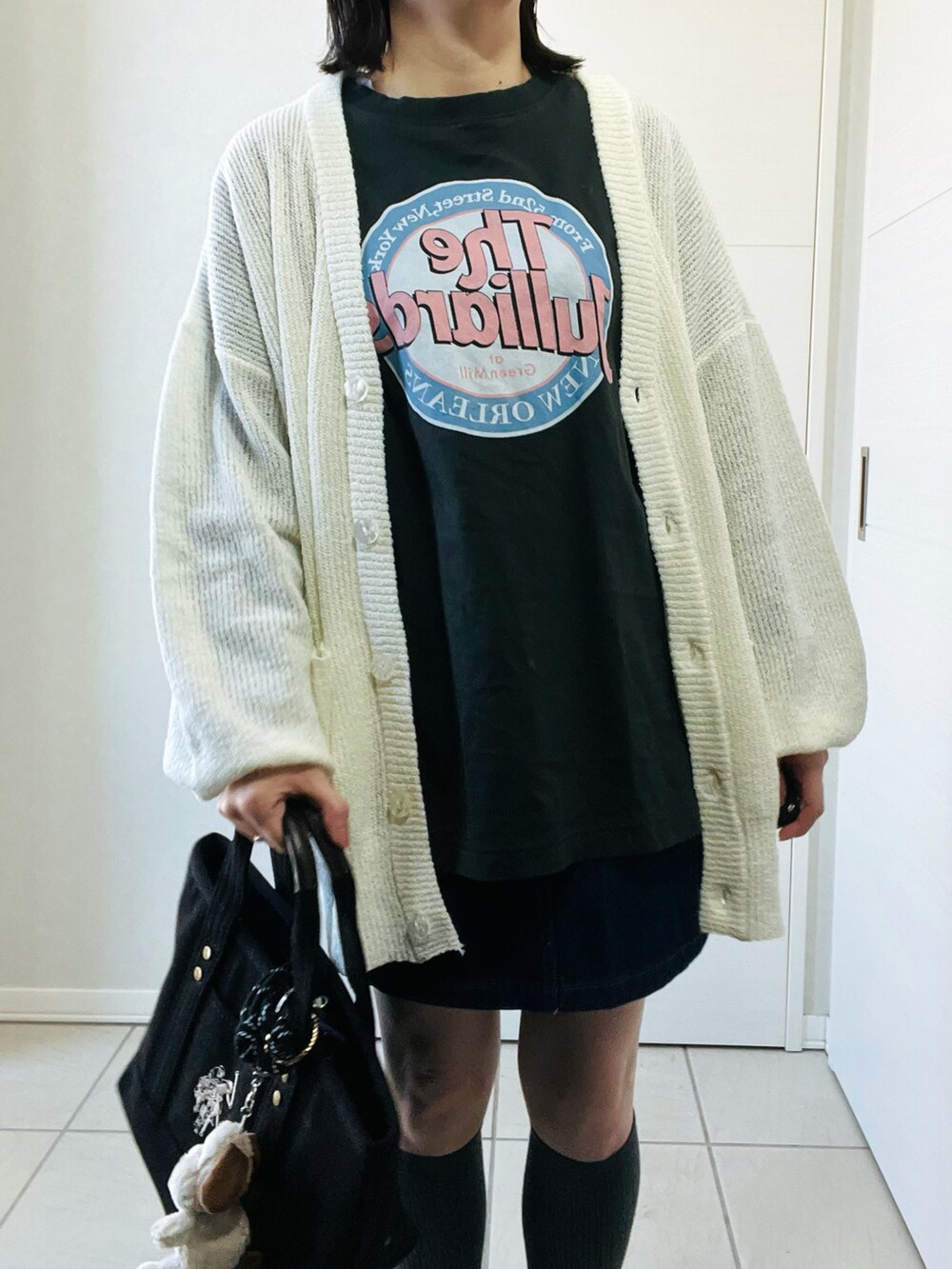 ホワイト系のカーディガン/ボレロ、グレー系のTシャツ/カットソー、ブルー系のデニムスカートを着用したレディースの春コーディネートの2枚目の写真