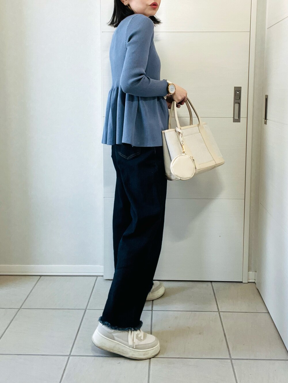 グレー系のカーディガン/ボレロ、ブルー系のデニムパンツ、ホワイト系のスニーカーを着用したレディースの春コーディネートの5枚目の写真