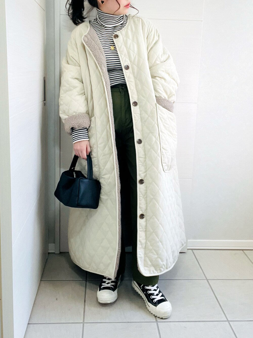 ホワイト系のその他アウター、その他のニット/セーター、ブラック系のスニーカーを着用したレディースの秋コーディネートの3枚目の写真