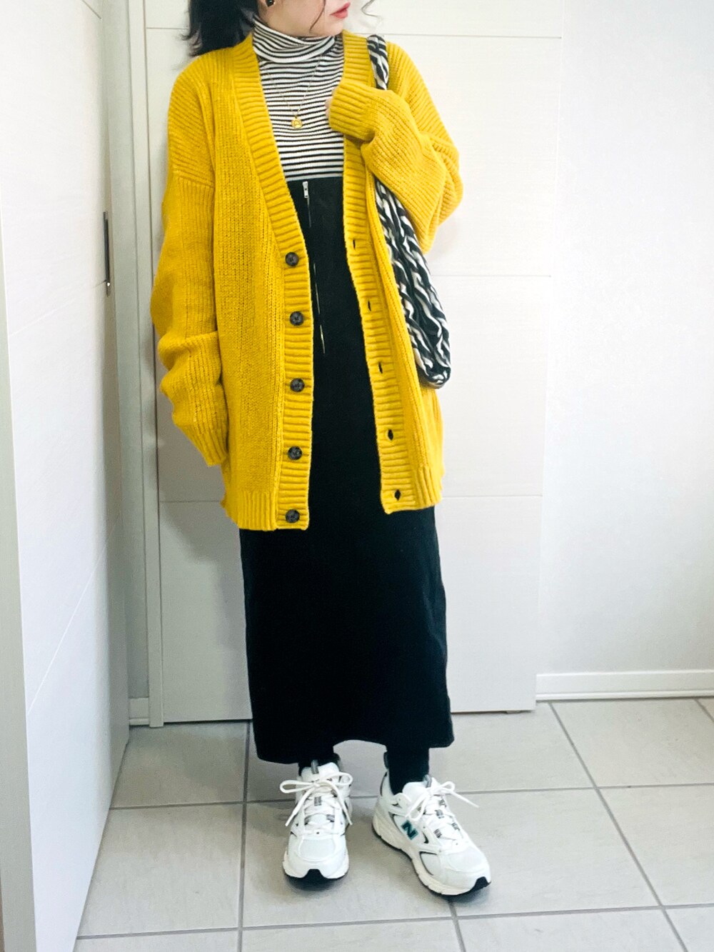 イエロー系のカーディガン/ボレロ、その他のニット/セーター、ブラック系のジャンパースカートを着用したレディースの冬コーディネートの3枚目の写真