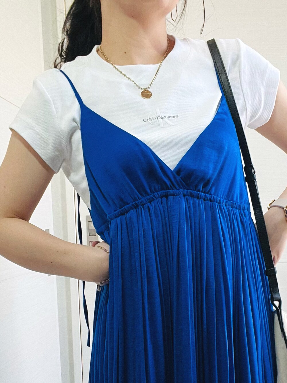 ホワイト系のTシャツ/カットソー、ブルー系のワンピース、ブラック系のスニーカーを着用したレディースの春コーディネートの3枚目の写真