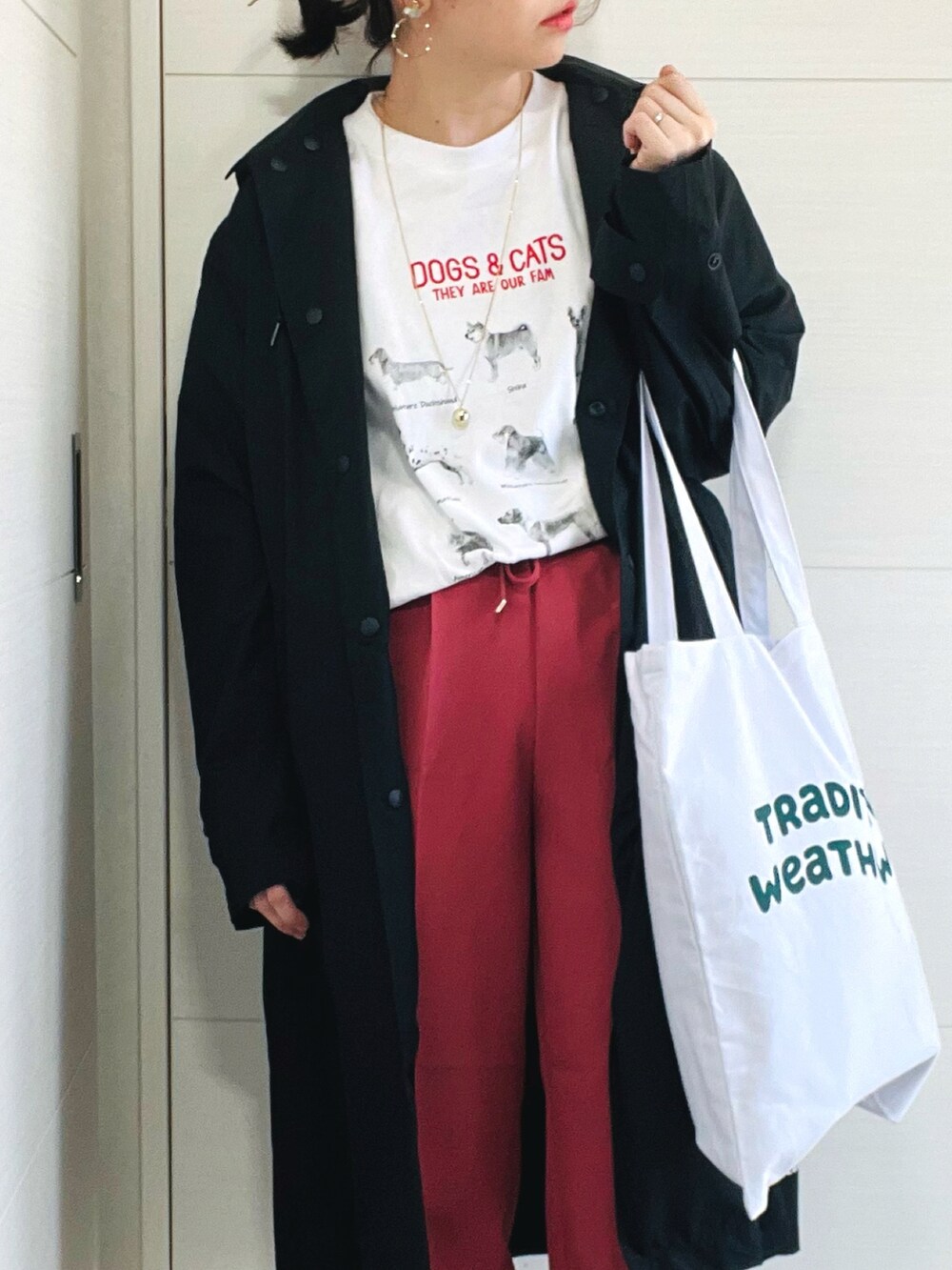 ホワイト系のTシャツ/カットソー、レッド系のスラックス、ブラック系のスニーカーを着用したレディースの春コーディネートの3枚目の写真