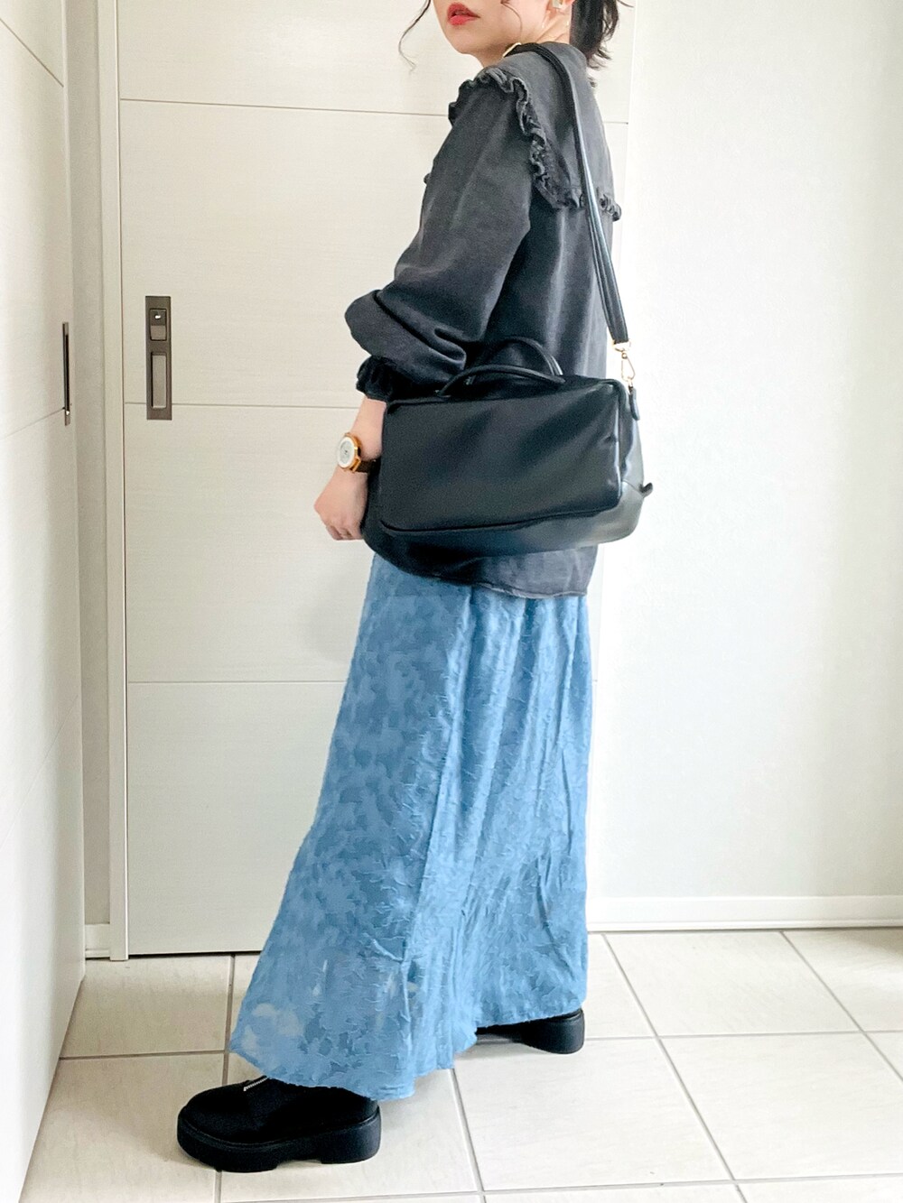 ブラック系のシャツ/ブラウス、ブルー系のスカート、ブラック系のブーツを着用したレディースの秋コーディネートの5枚目の写真