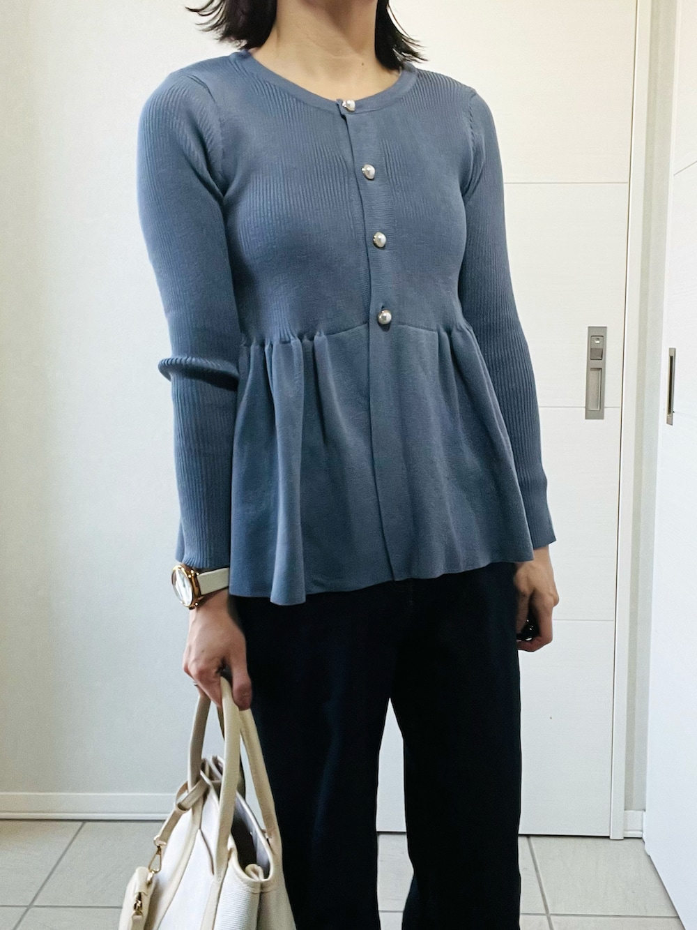 グレー系のカーディガン/ボレロ、ブルー系のデニムパンツ、ホワイト系のスニーカーを着用したレディースの春コーディネートの2枚目の写真