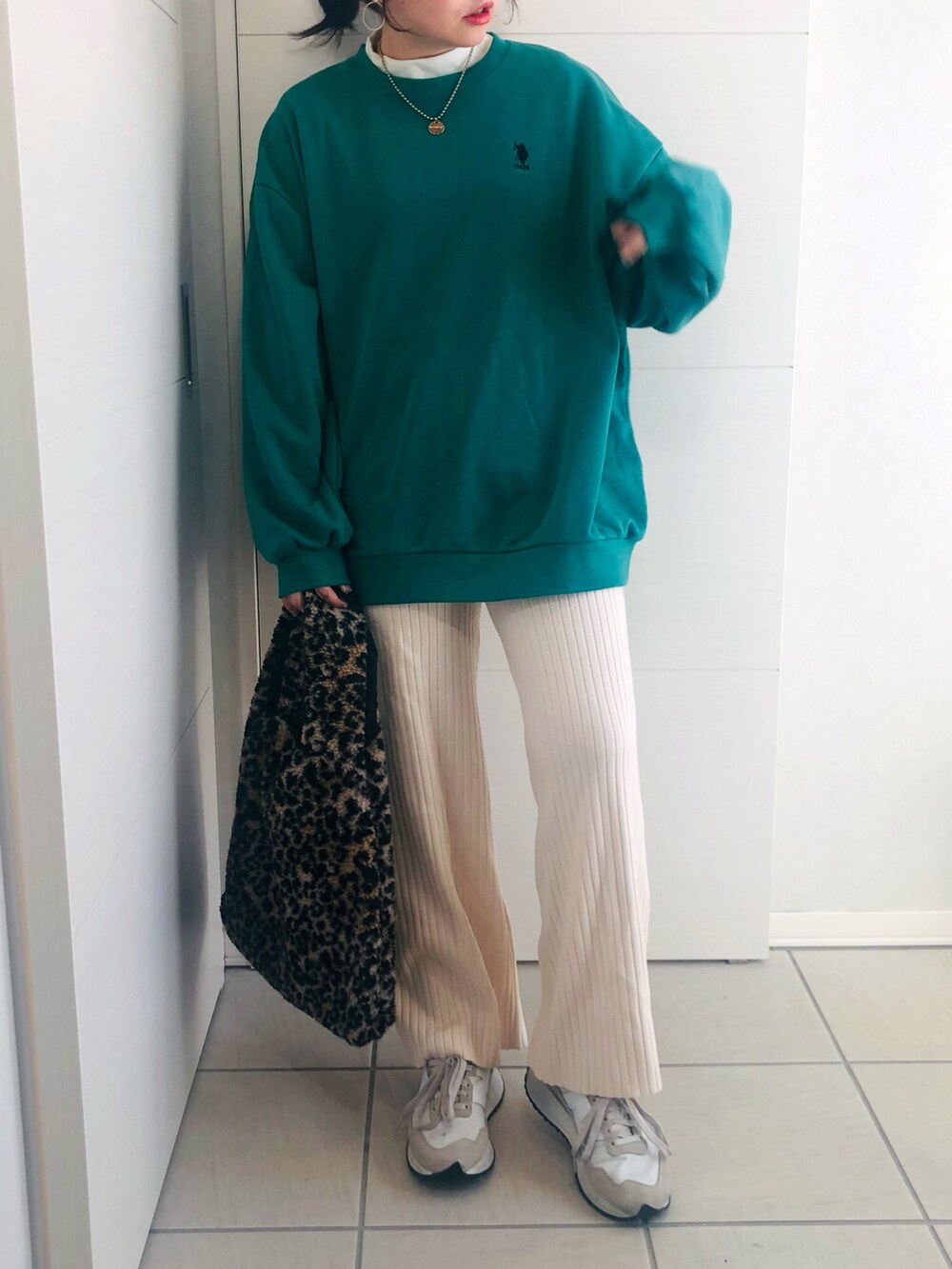 グリーン系のスウェット、ホワイト系のその他パンツ、ホワイト系のスニーカーを着用したレディースの冬コーディネートの2枚目の写真