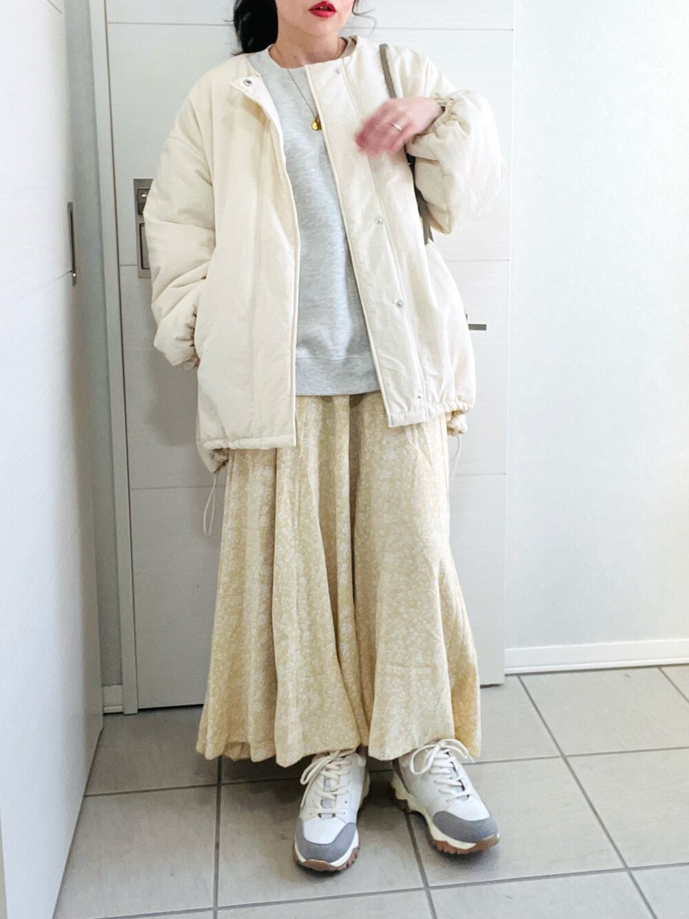 ホワイト系のブルゾン、グレー系のスウェット、イエロー系のスカートを着用したレディースの冬コーディネートの3枚目の写真