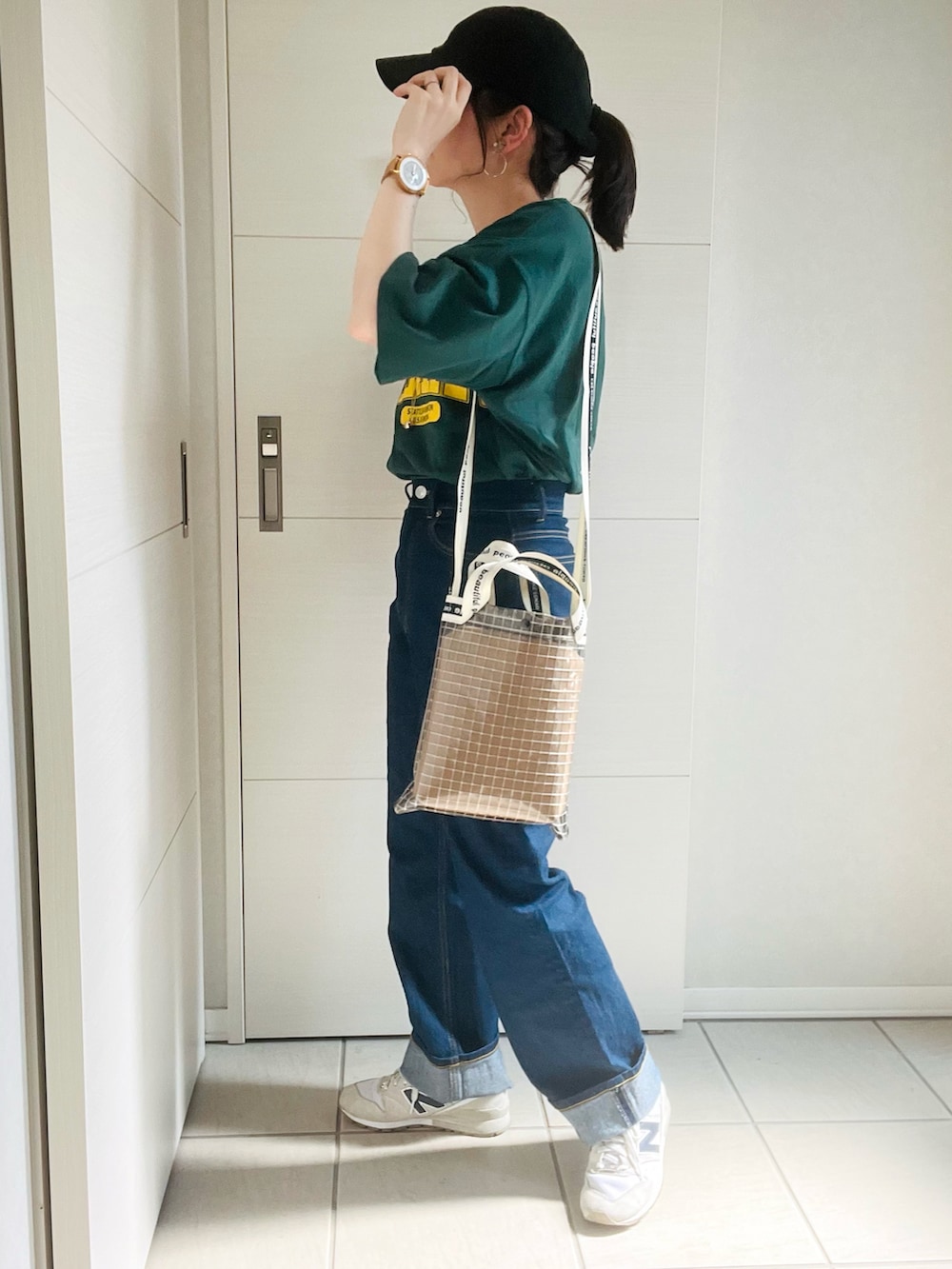 グリーン系のTシャツ/カットソー、ブルー系のデニムパンツ、ホワイト系のスニーカーを着用したレディースの夏コーディネートの5枚目の写真