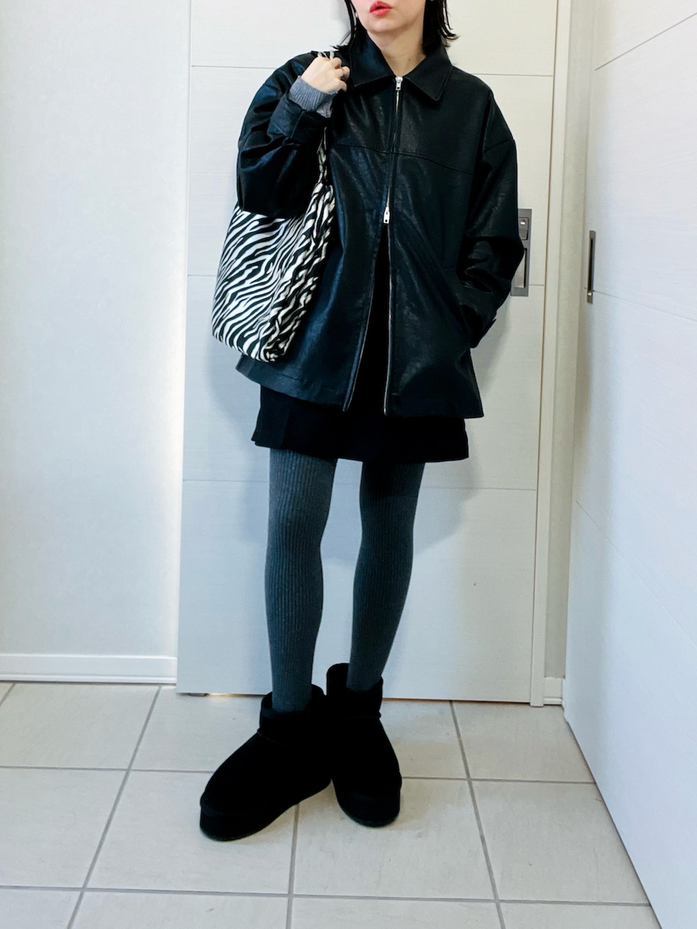 ブラック系のブルゾン、グレー系のニット/セーター、ブラック系のその他パンツを着用したレディースの冬コーディネートの2枚目の写真