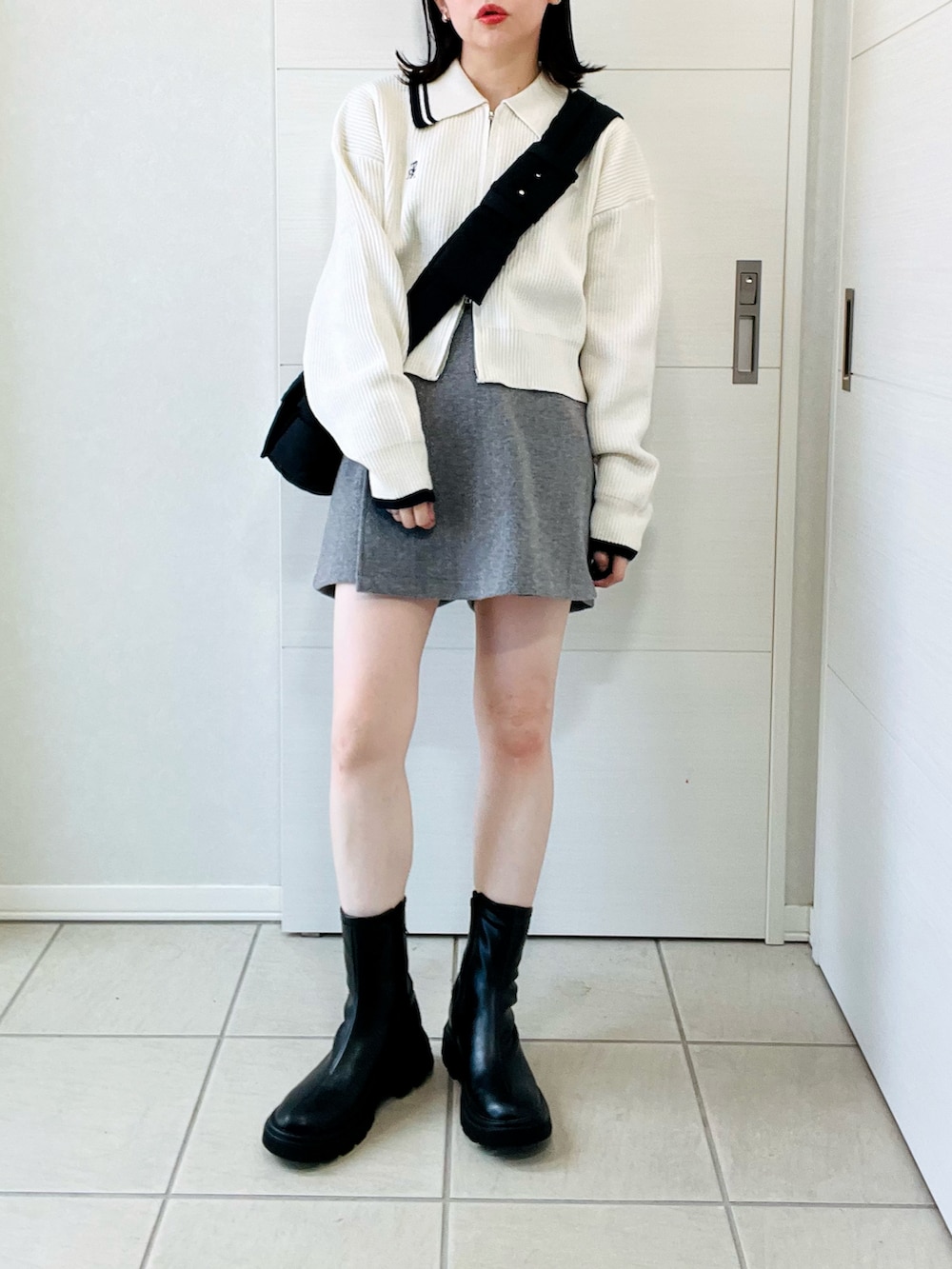 ホワイト系のニット/セーター、ブラック系のブーツ、グレー系のその他パンツを着用したレディースの秋コーディネートの4枚目の写真