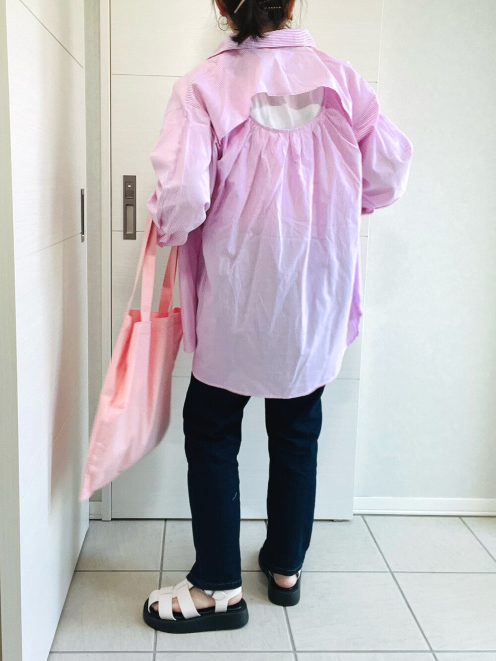 ピンク系のシャツ/ブラウス、ホワイト系のTシャツ/カットソー、ブルー系のデニムパンツを着用したレディースの春コーディネートの2枚目の写真
