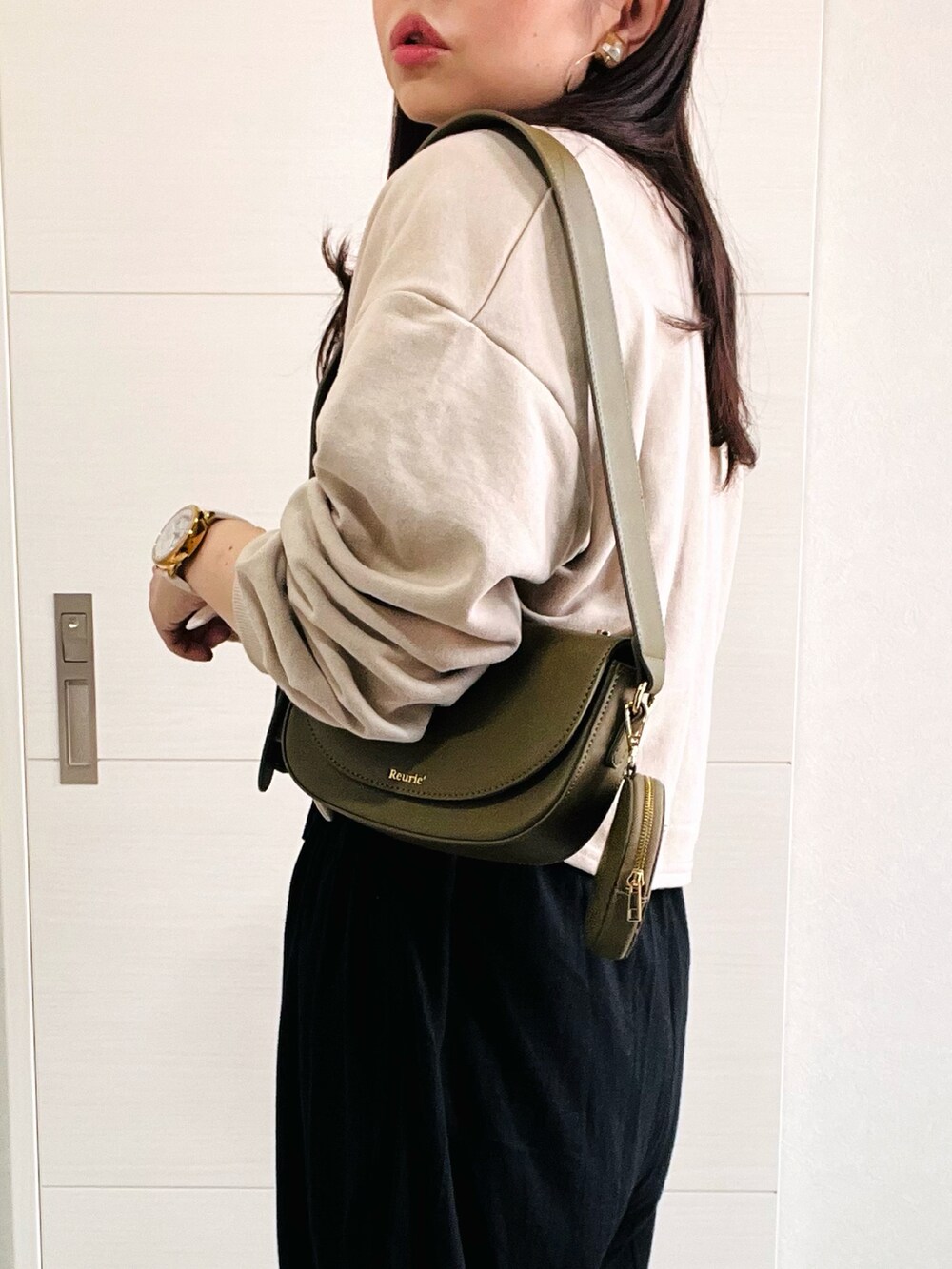 ブラック系のサロペット/オーバーオール、ベージュ系のカーディガン/ボレロ、ホワイト系のスニーカーを着用したレディースの夏コーディネートの2枚目の写真