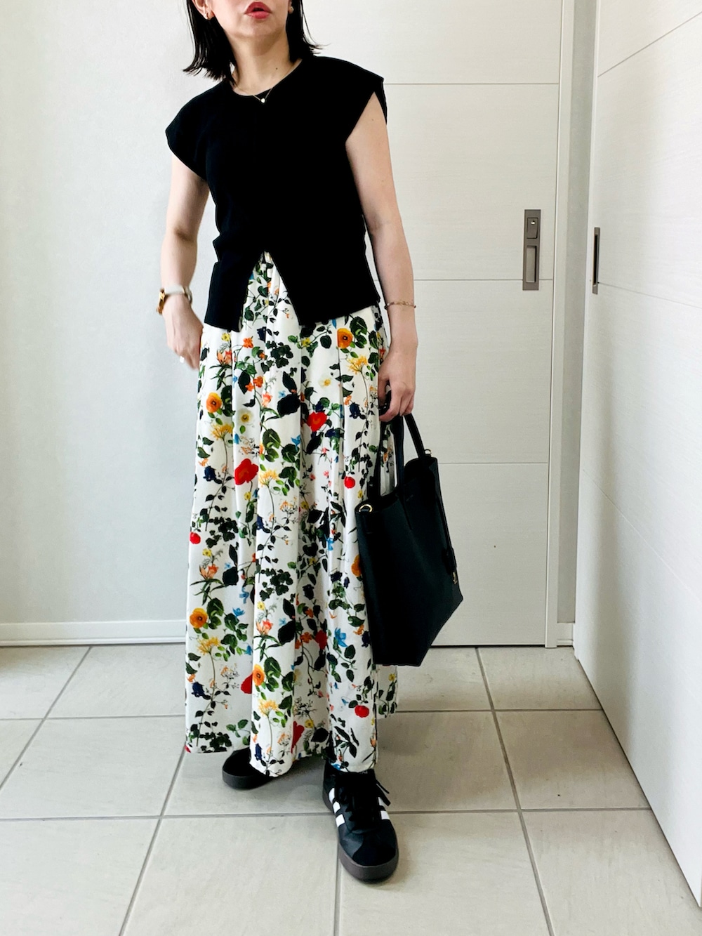 ホワイト系のその他パンツ、ブラック系のニット/セーター、ブラック系のスニーカーを着用したレディースの夏コーディネートの3枚目の写真