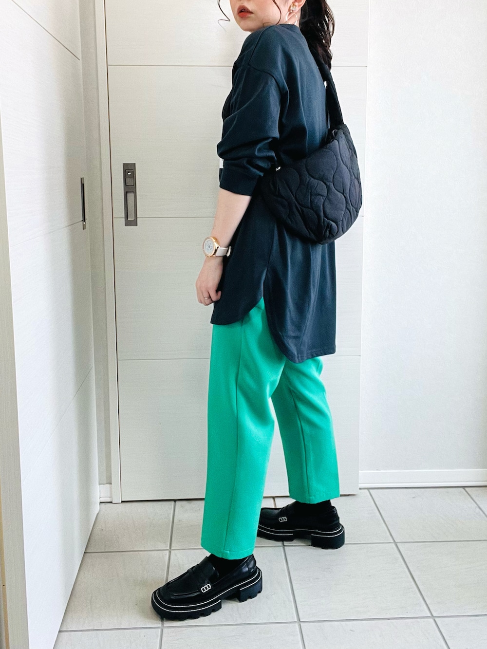 ブラック系のTシャツ/カットソー、グリーン系のスラックス、ブラック系のローファーを着用したレディースの春コーディネートの5枚目の写真
