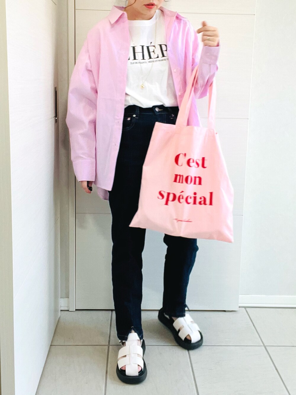 ピンク系のシャツ/ブラウス、ホワイト系のTシャツ/カットソー、ブルー系のデニムパンツを着用したレディースの春コーディネートの4枚目の写真