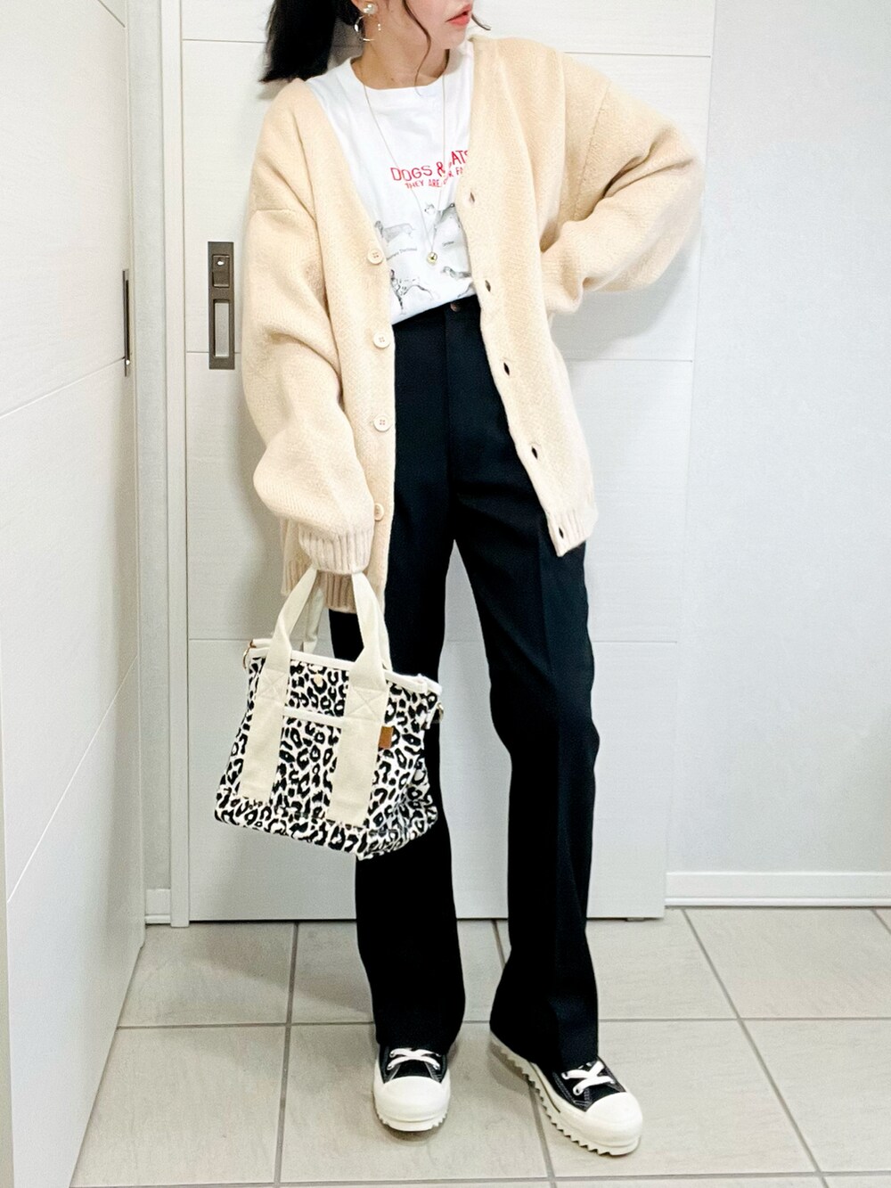 ホワイト系のカーディガン/ボレロ、ホワイト系のTシャツ/カットソー、ブラック系のスラックスを着用したレディースの秋コーディネートの2枚目の写真