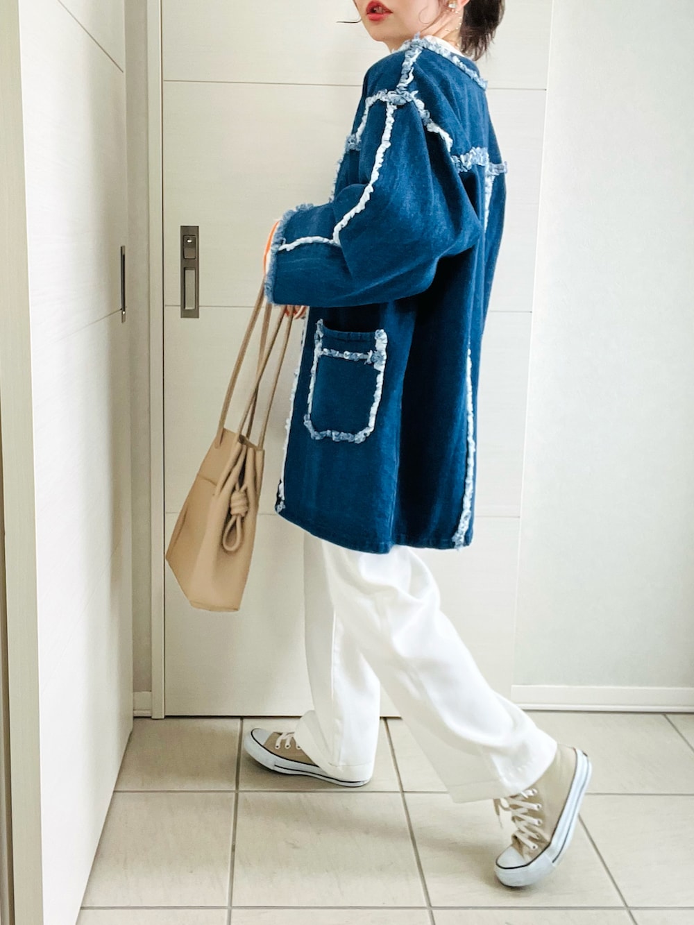 オレンジ系のTシャツ/カットソー、ブルー系のデニムジャケット、ホワイト系のサロペット/オーバーオールを着用したレディースの春コーディネートの3枚目の写真