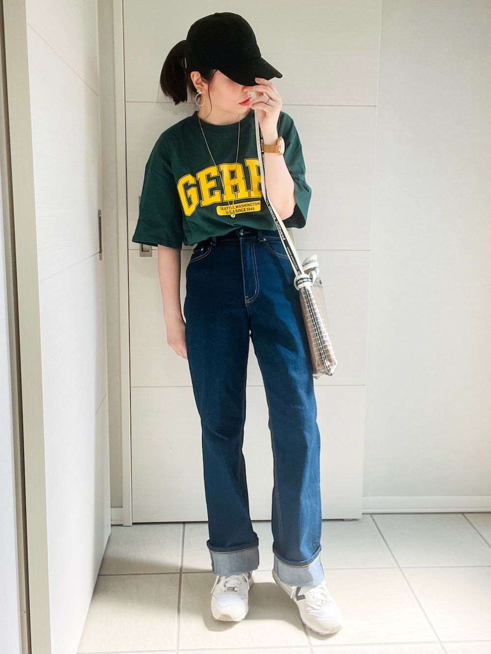 グリーン系のTシャツ/カットソー、ブルー系のデニムパンツ、ホワイト系のスニーカーを着用したレディースの夏コーディネートの3枚目の写真