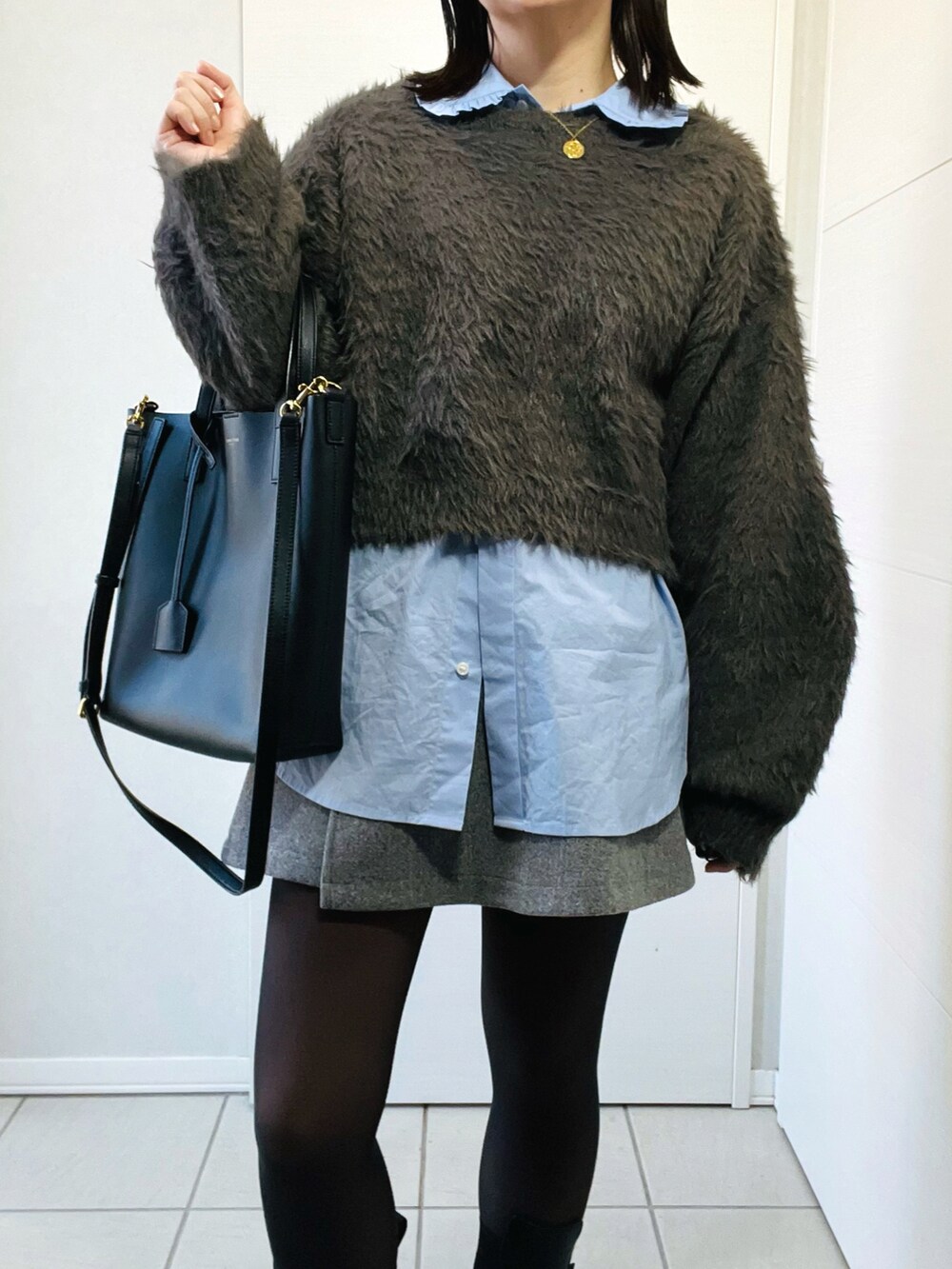 グレー系のニット/セーター、ブルー系のシャツ/ブラウス、グレー系のその他パンツを着用したレディースの冬コーディネートの2枚目の写真
