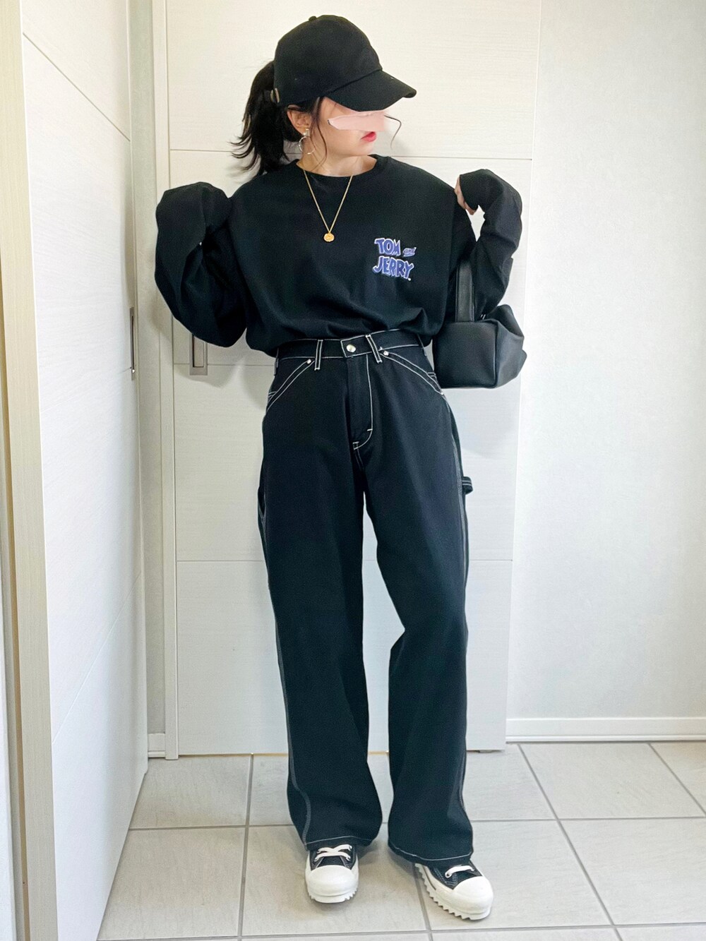 ブラック系のTシャツ/カットソー、ブラック系のデニムパンツ、ブラック系のスニーカーを着用したレディースの秋コーディネートの5枚目の写真