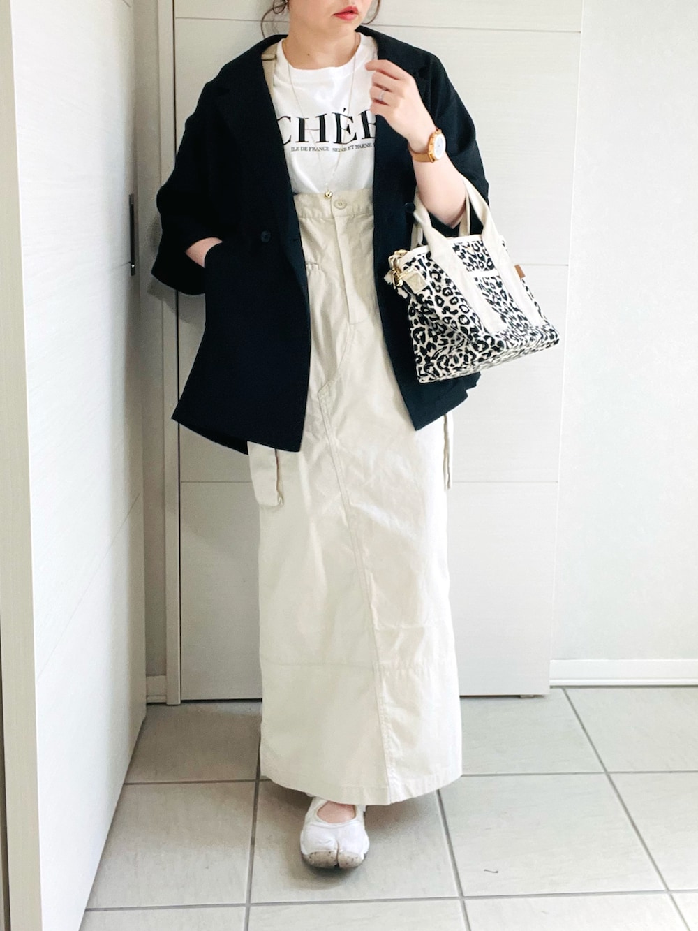 ホワイト系のTシャツ/カットソー、ブラック系のシャツ/ブラウス、ホワイト系のスカートを着用したレディースの春コーディネートの5枚目の写真