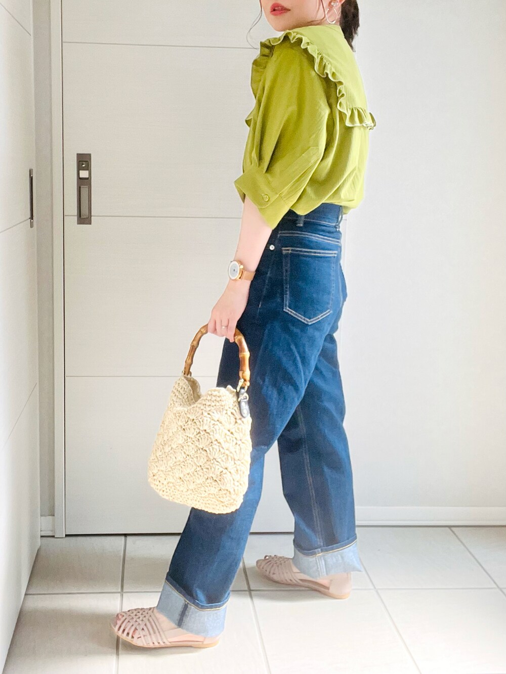 グリーン系のシャツ/ブラウス、ブルー系のデニムパンツ、グレー系のサンダルを着用したレディースの夏コーディネートの2枚目の写真