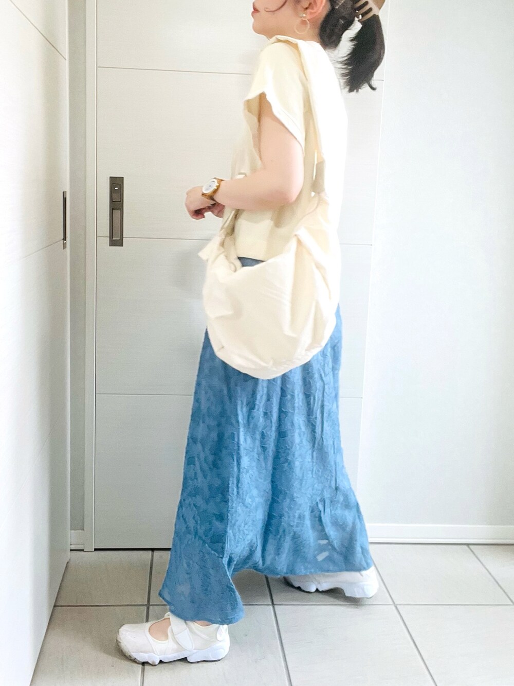 ホワイト系のカーディガン/ボレロ、ブルー系のスカート、ホワイト系のサンダルを着用したレディースの夏コーディネートの4枚目の写真