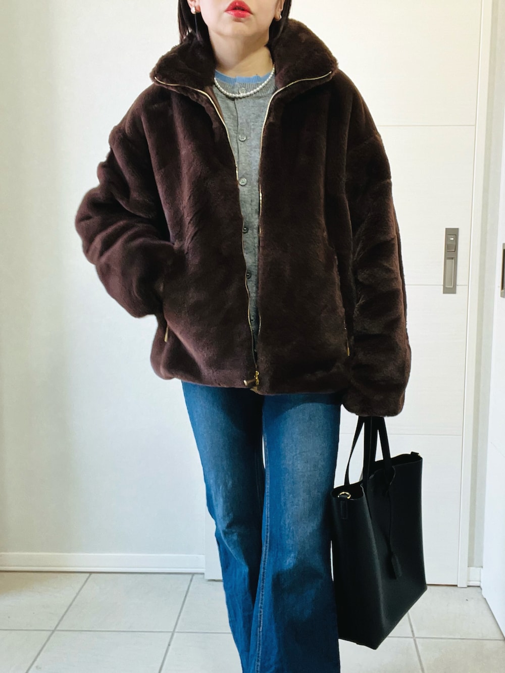 ブラウン系のジャケット/アウター、ブルー系のデニムパンツ、ブラック系のブーツを着用したレディースの冬コーディネートの2枚目の写真