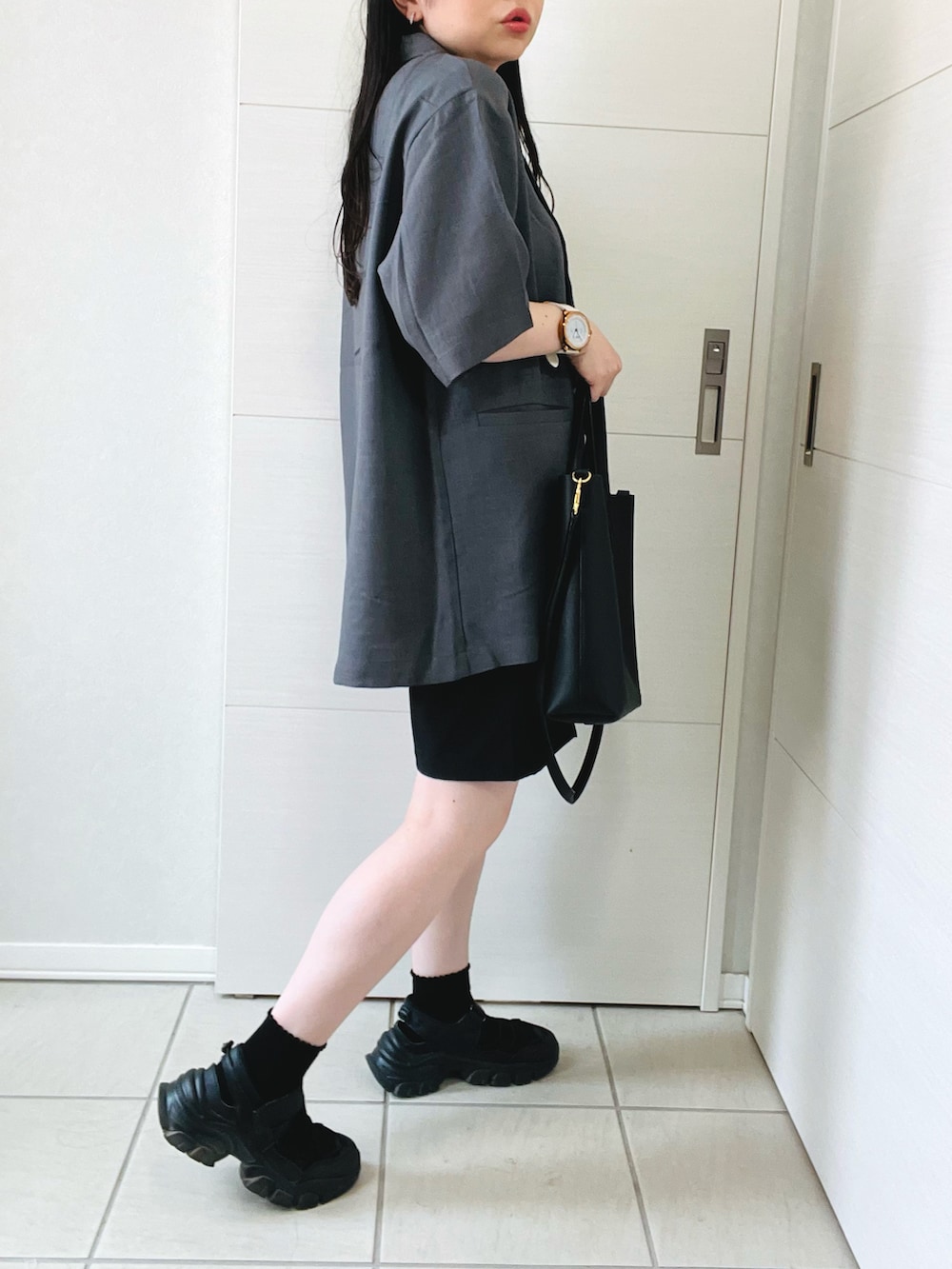 グレー系のテーラードジャケット、ブラック系のその他パンツ、ブラック系のサンダルを着用したレディースの夏コーディネートの4枚目の写真