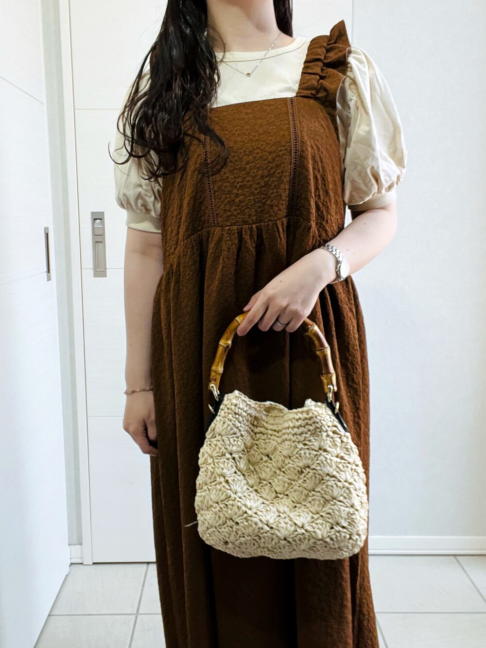 ブラウン系のワンピース、グレー系のサンダル、ベージュ系のショルダーバッグを着用したレディースの春コーディネートの2枚目の写真