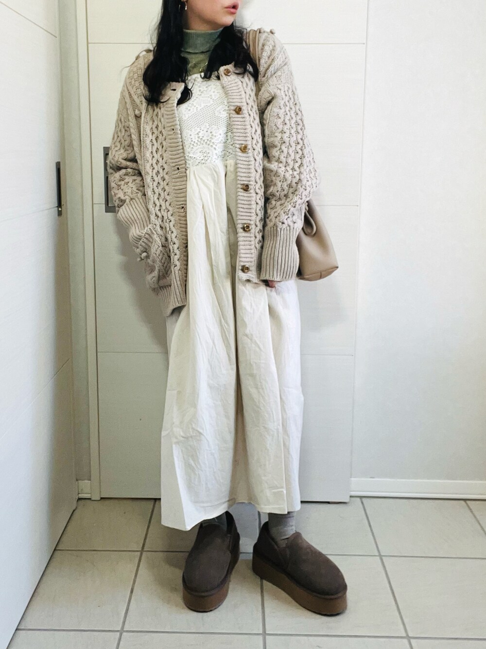 ホワイト系のワンピース、グリーン系のTシャツ/カットソー、ベージュ系のカーディガン/ボレロを着用したレディースの冬コーディネートの4枚目の写真