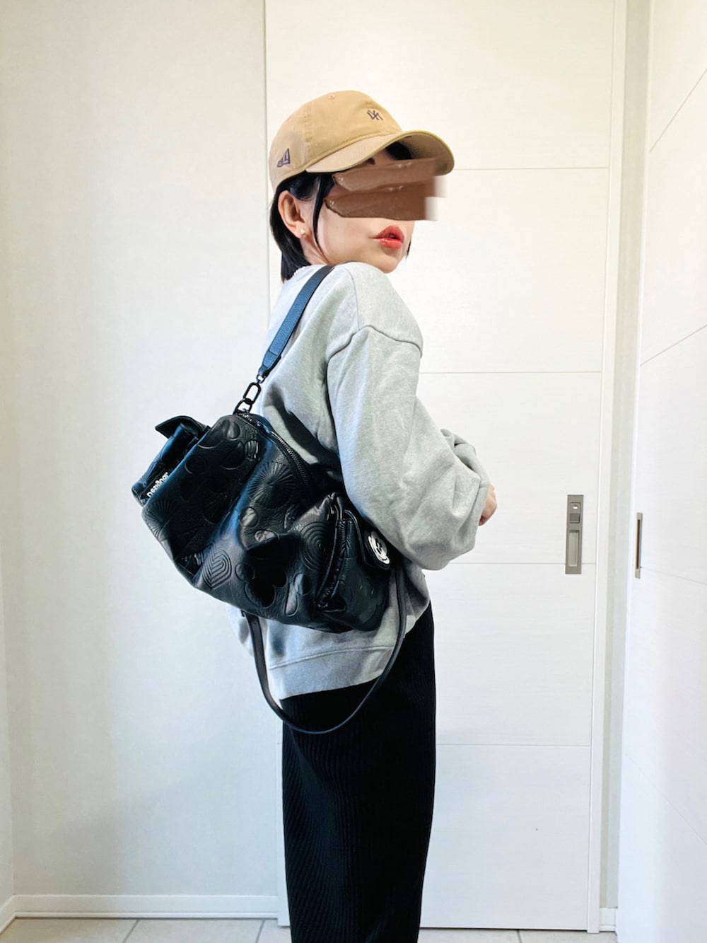 グレー系のスウェット、ブラック系のスカート、ブラック系のスニーカーを着用したレディースの秋コーディネートの3枚目の写真