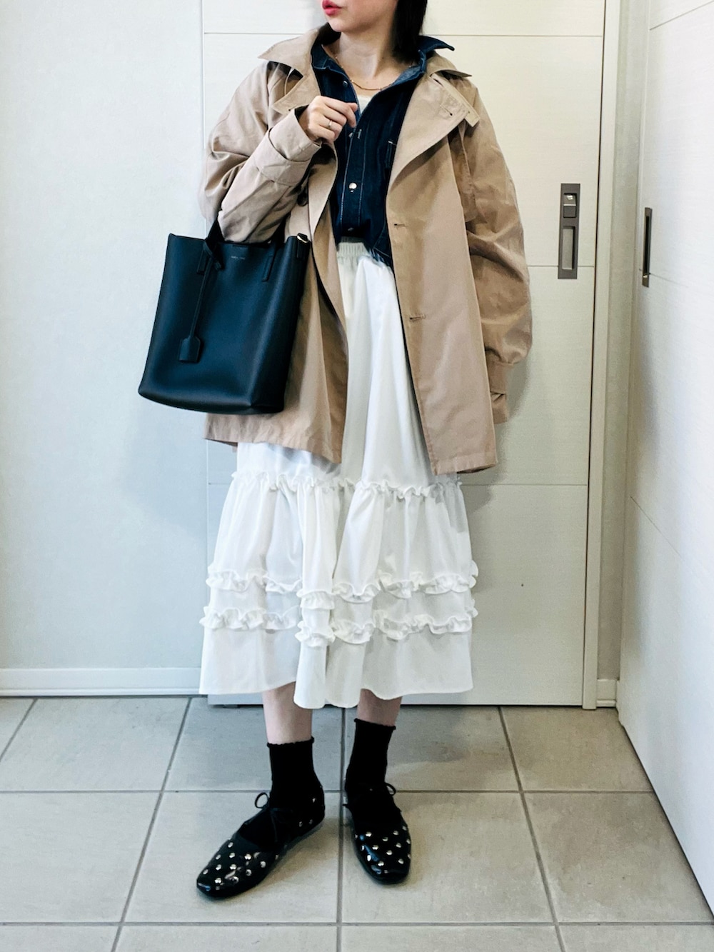 ベージュ系のトレンチコート、ブルー系のシャツ/ブラウス、ホワイト系のスカートを着用したレディースの春コーディネートの4枚目の写真