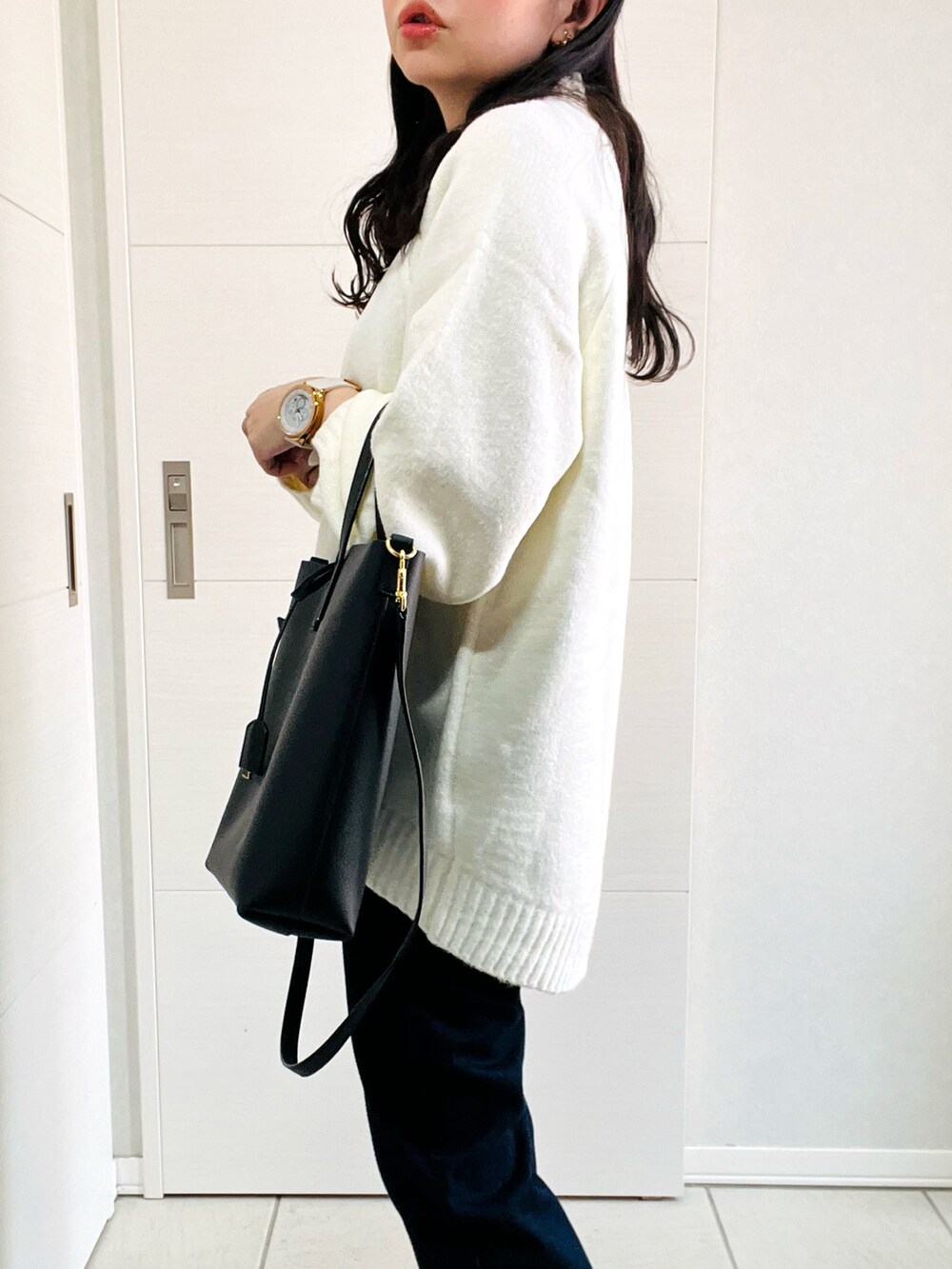 ホワイト系のニット/セーター、ブルー系のデニムパンツ、グレー系のスニーカーを着用したレディースの秋コーディネートの3枚目の写真