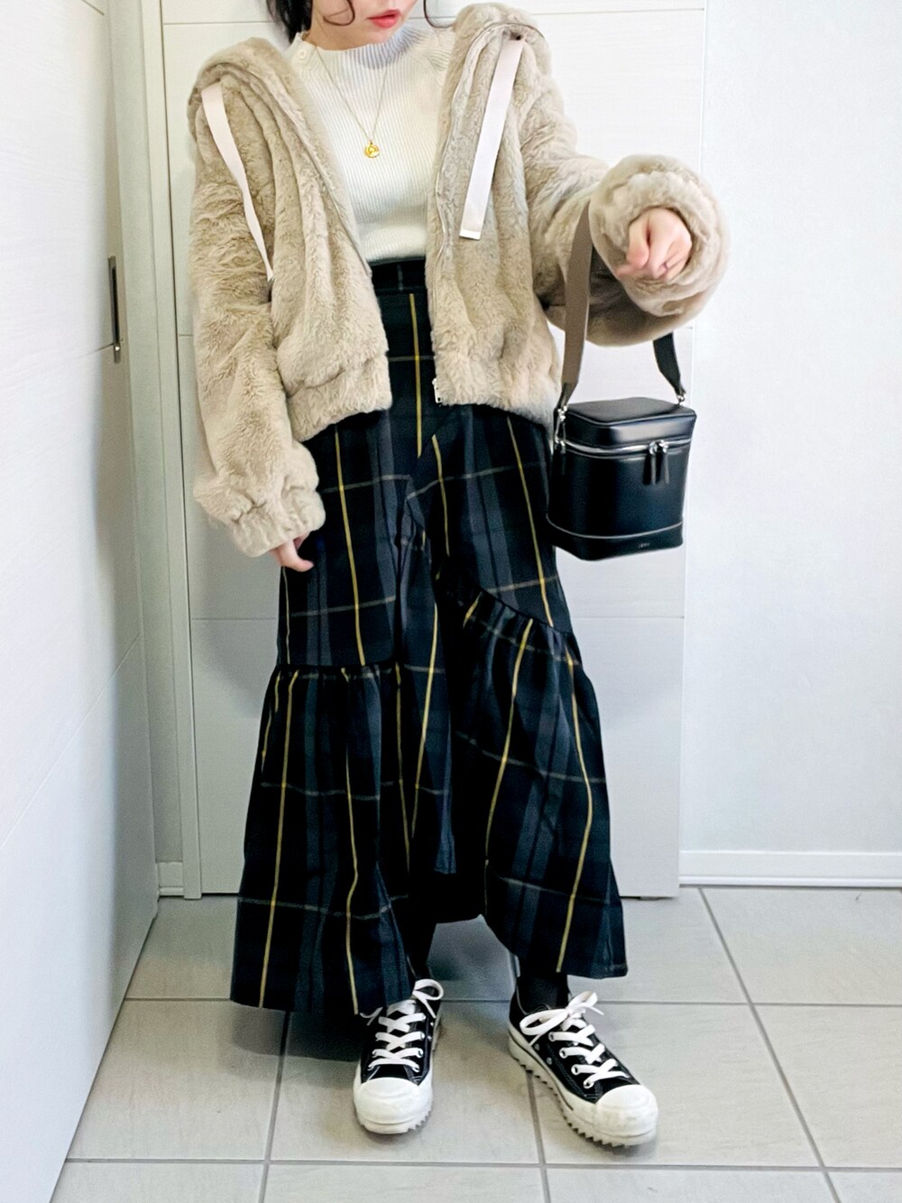 ベージュ系のブルゾン、ブラック系のスカート、ブラック系のスニーカーを着用したレディースの冬コーディネートの4枚目の写真