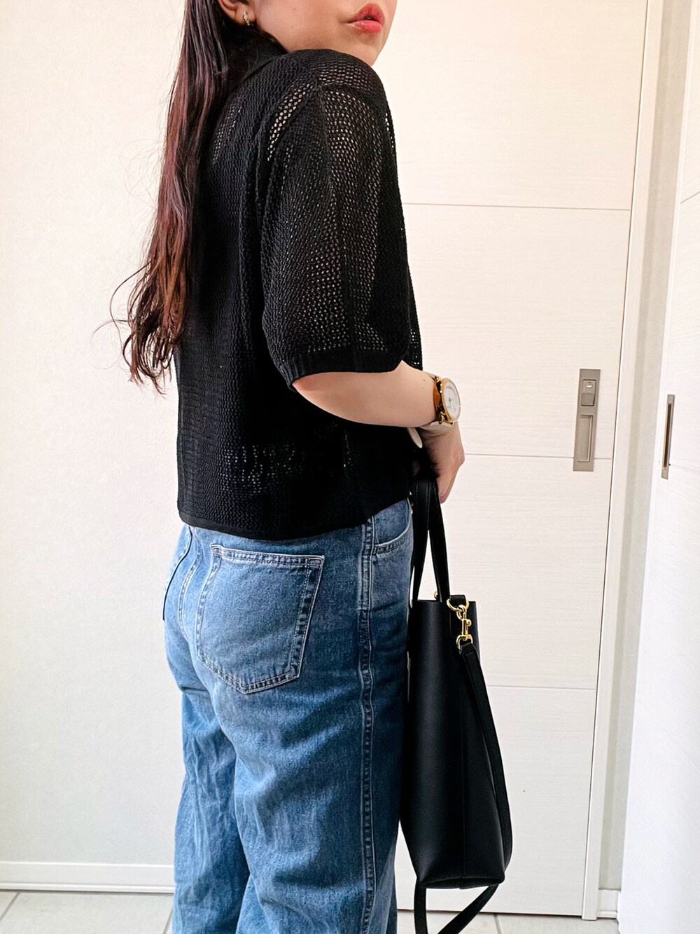 ブラック系のカーディガン/ボレロ、ブルー系のデニムパンツ、グレー系のサンダルを着用したレディースの夏コーディネートの3枚目の写真