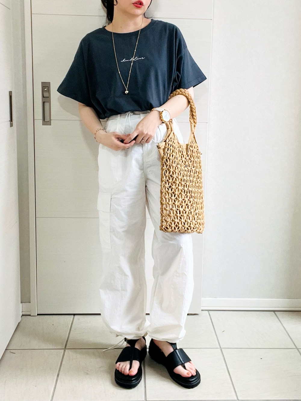 グレー系のTシャツ/カットソー、ホワイト系のその他パンツ、ブラック系のサンダルを着用したレディースの夏コーディネートの3枚目の写真