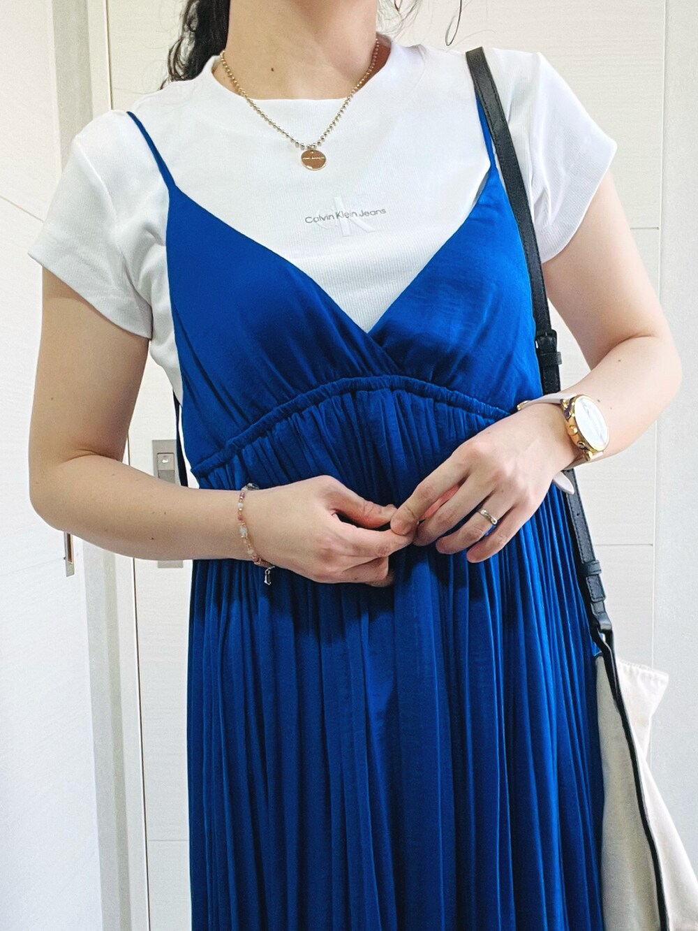 ホワイト系のTシャツ/カットソー、ブルー系のワンピース、ブラック系のスニーカーを着用したレディースの春コーディネートの2枚目の写真