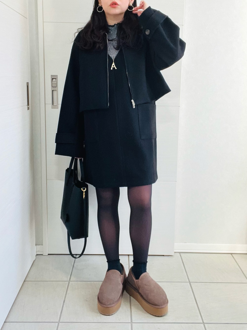 ブラック系のブルゾン、グレー系のTシャツ/カットソー、ブラック系のジャンパースカートを着用したレディースの冬コーディネートの2枚目の写真