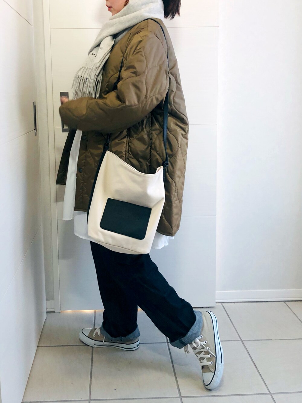 ブラウン系のブルゾン、ブルー系のセットアップ、ホワイト系のショルダーバッグを着用したレディースの秋コーディネートの5枚目の写真