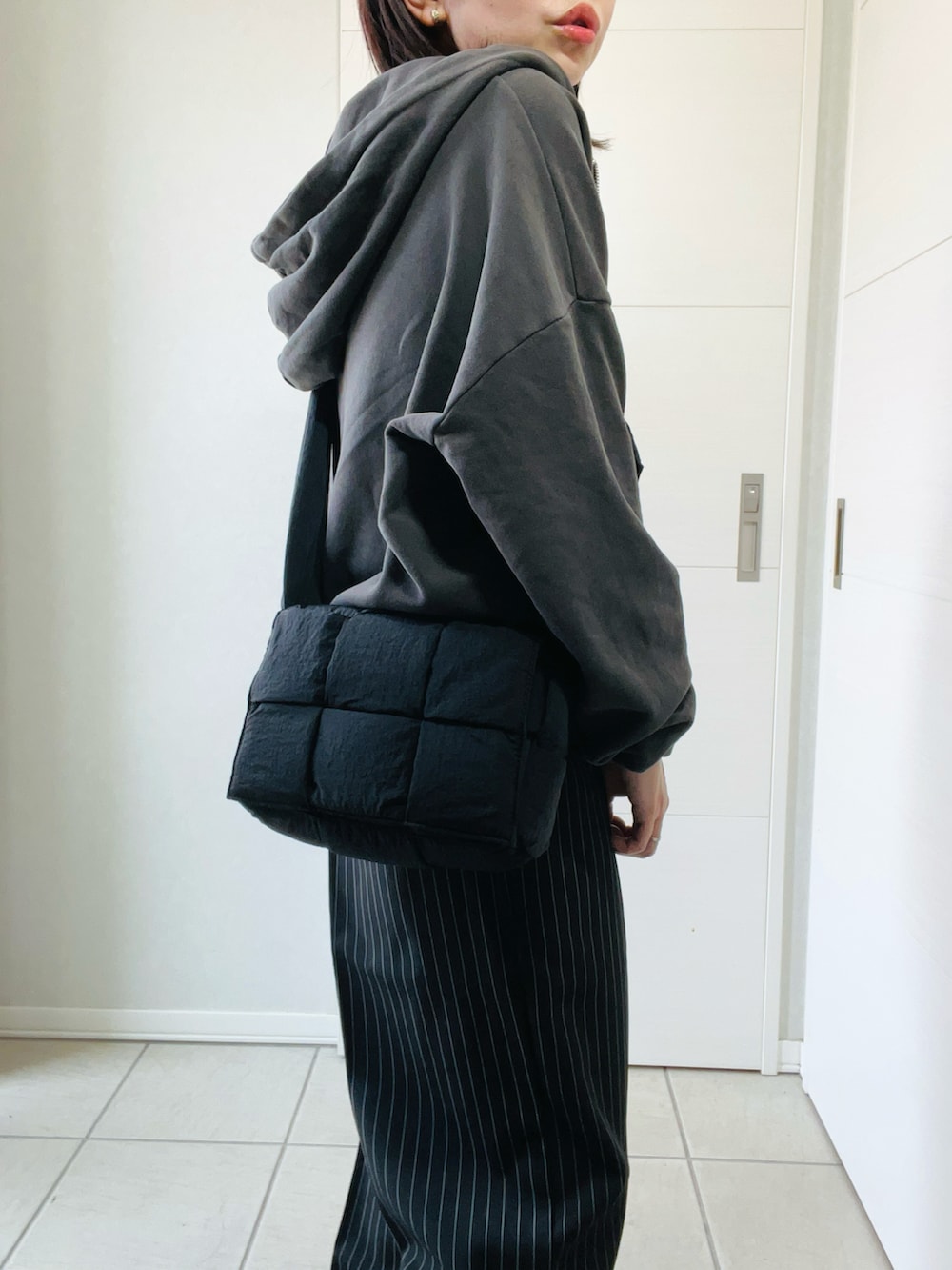 ブラック系のデニムパンツ、グレー系のパーカー、ブラック系のブーツを着用したレディースの秋コーディネートの3枚目の写真