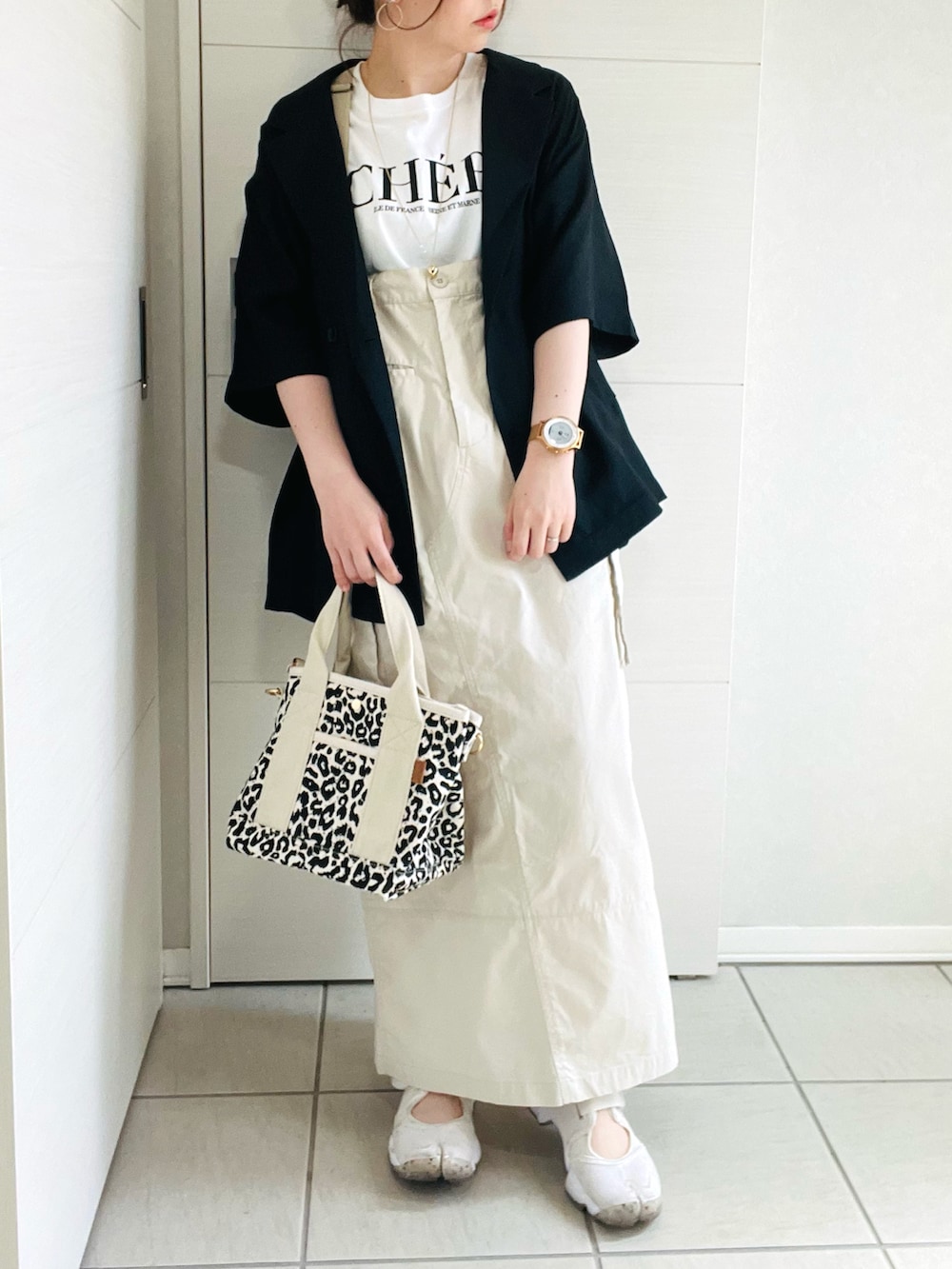 ホワイト系のTシャツ/カットソー、ブラック系のシャツ/ブラウス、ホワイト系のスカートを着用したレディースの春コーディネートの2枚目の写真