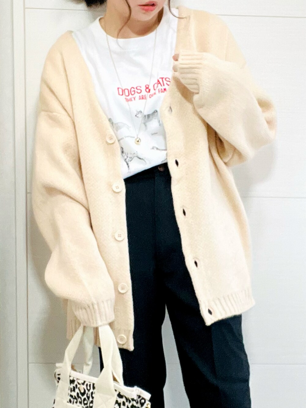 ホワイト系のカーディガン/ボレロ、ホワイト系のTシャツ/カットソー、ブラック系のスラックスを着用したレディースの秋コーディネートの3枚目の写真