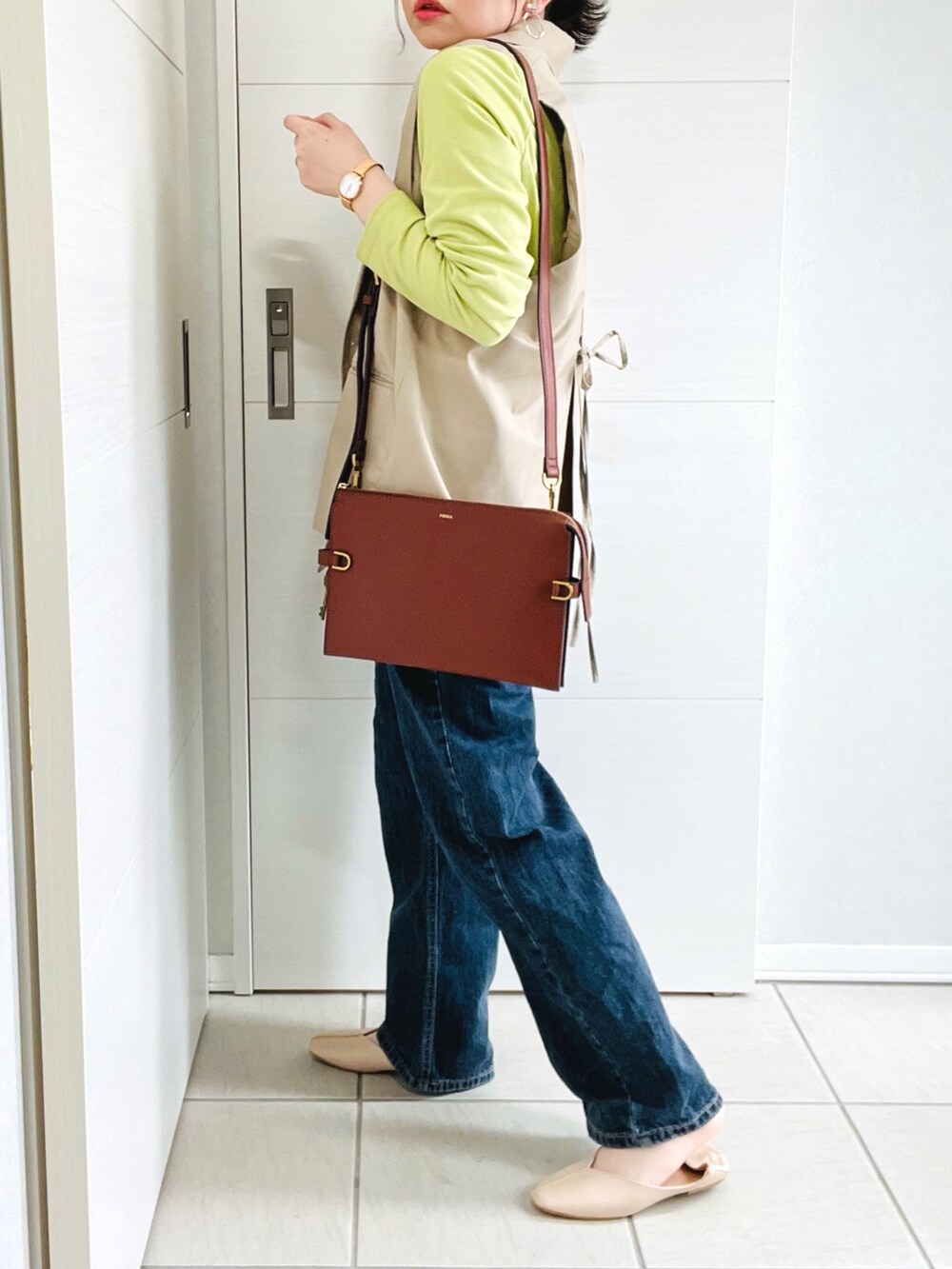 ブラウン系のメッセンジャーバッグ、グリーン系のTシャツ/カットソー、ベージュ系のテーラードジャケットを着用したレディースの春コーディネートの4枚目の写真