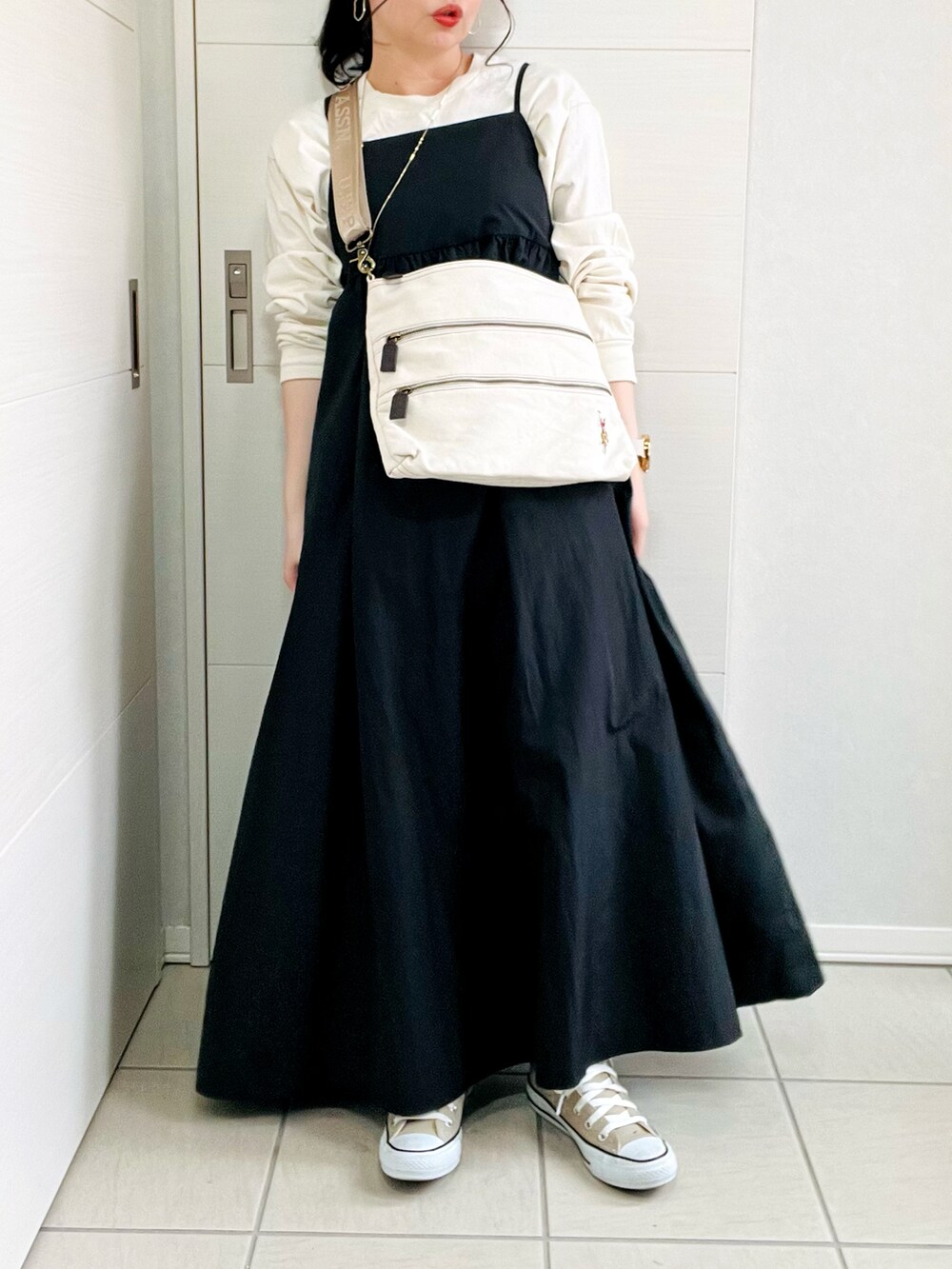 ブラック系のワンピース、ベージュ系のTシャツ/カットソー、ベージュ系のスニーカーを着用したレディースの春コーディネートの4枚目の写真