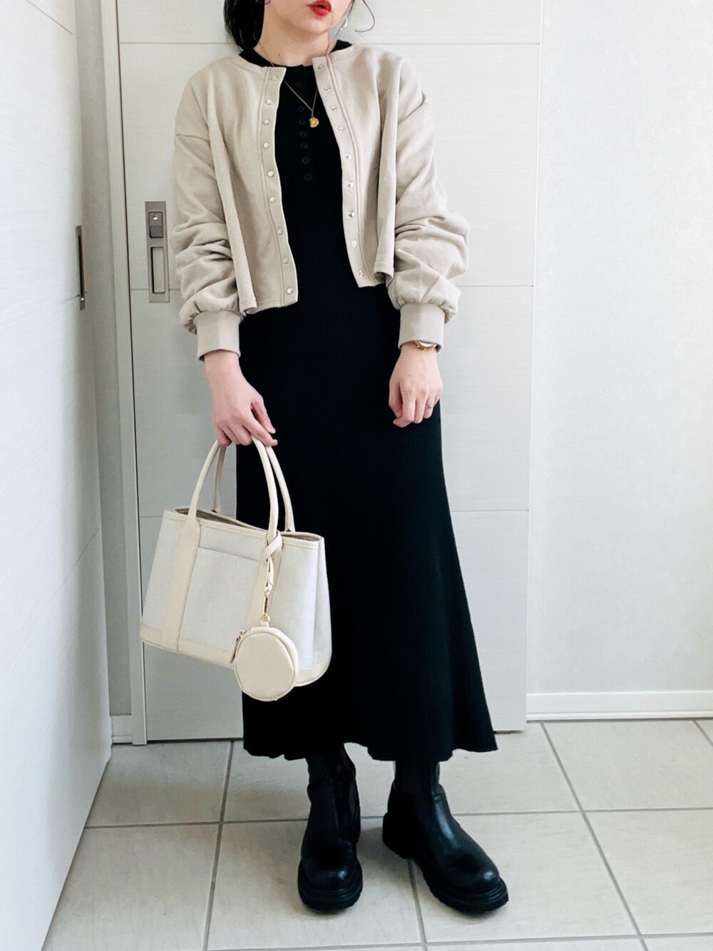 ベージュ系のカーディガン/ボレロ、ブラック系のワンピース、ブラック系のブーツを着用したレディースの冬コーディネートの4枚目の写真