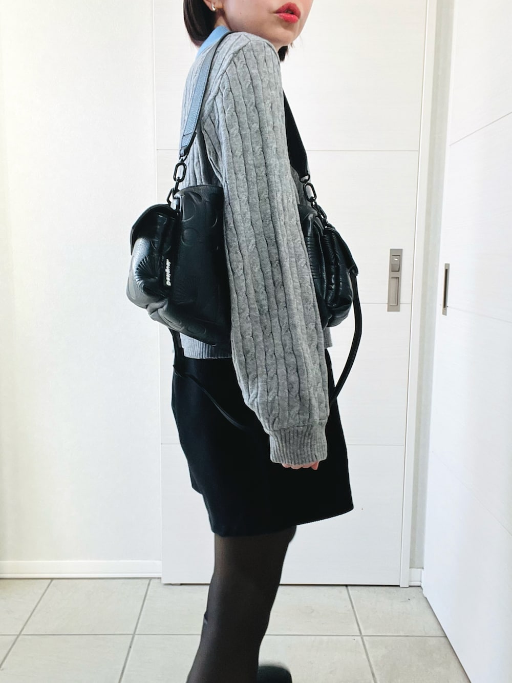 グレー系のニット/セーター、ブラック系のその他パンツ、ブラック系のブーツを着用したレディースの冬コーディネートの3枚目の写真