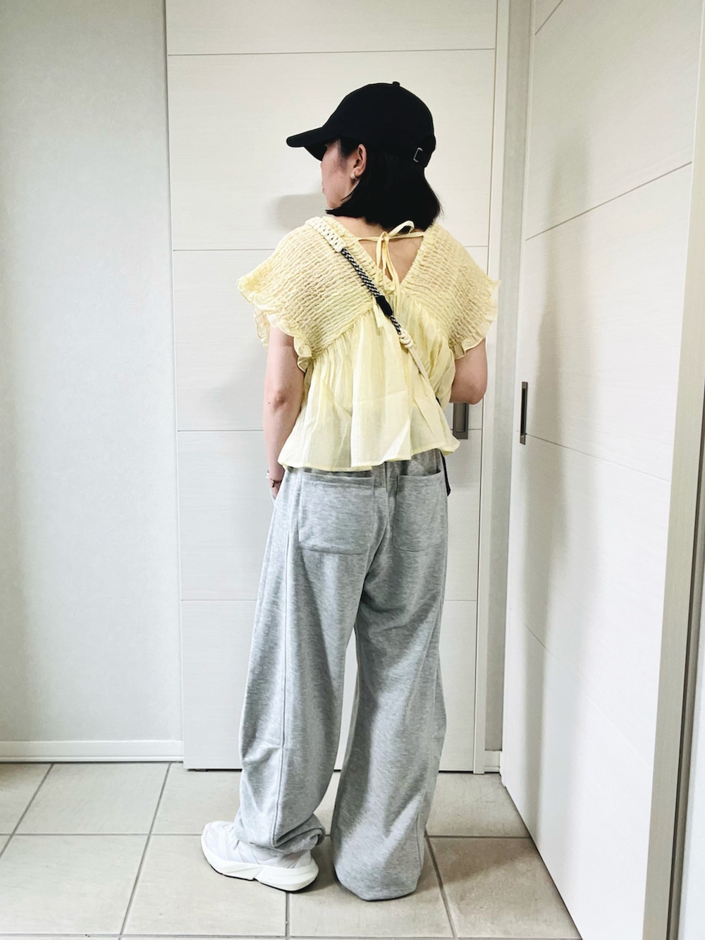 グレー系のスウェットパンツ、ホワイト系のスニーカー、イエロー系のシャツ/ブラウスを着用したレディースの夏コーディネートの5枚目の写真