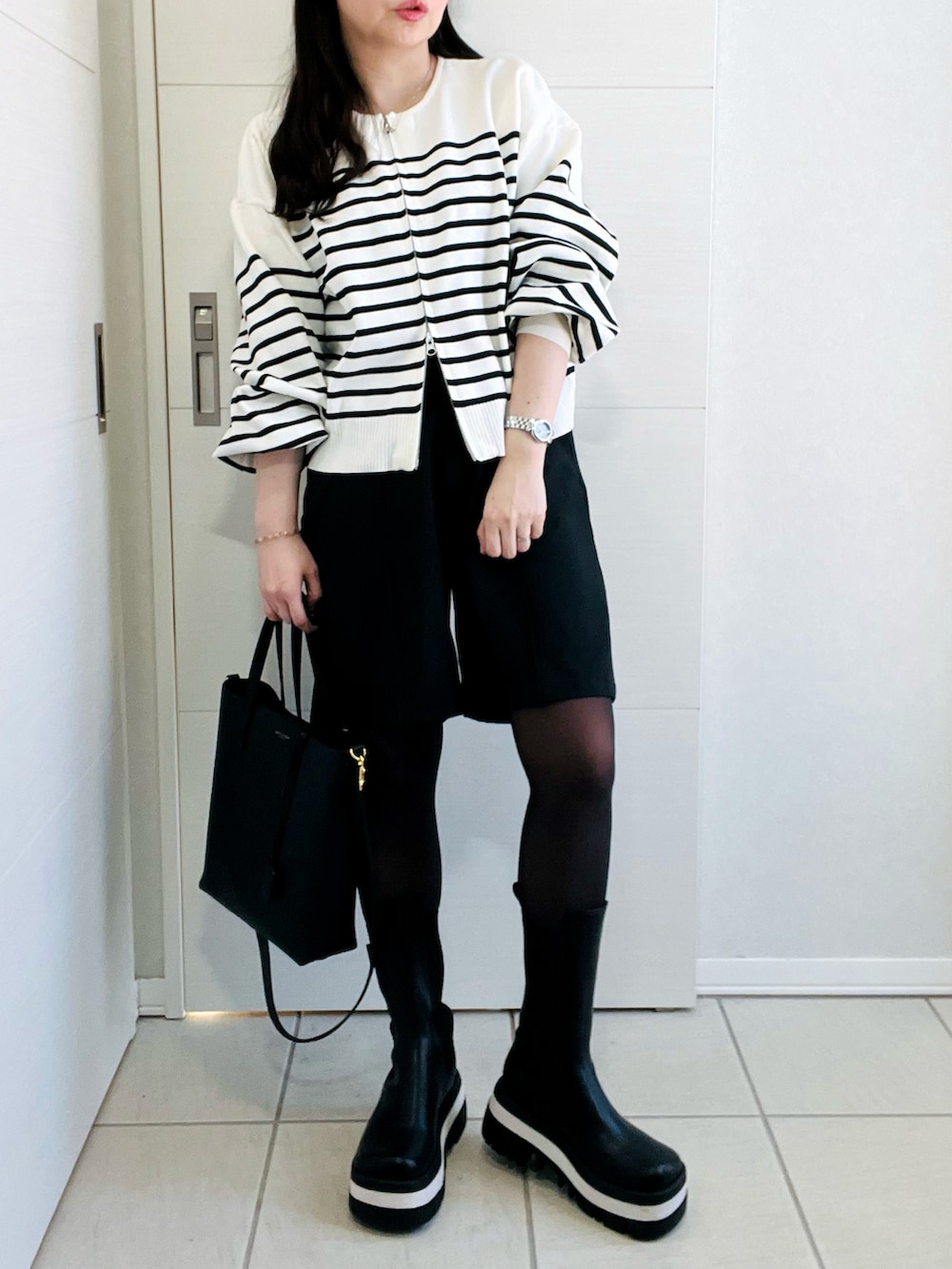 ホワイト系のカーディガン/ボレロ、ブラック系のその他パンツ、ブラック系のブーツを着用したレディースの冬コーディネートの4枚目の写真